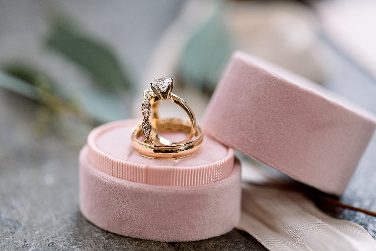 gold wedding rings rest in pink ring box 