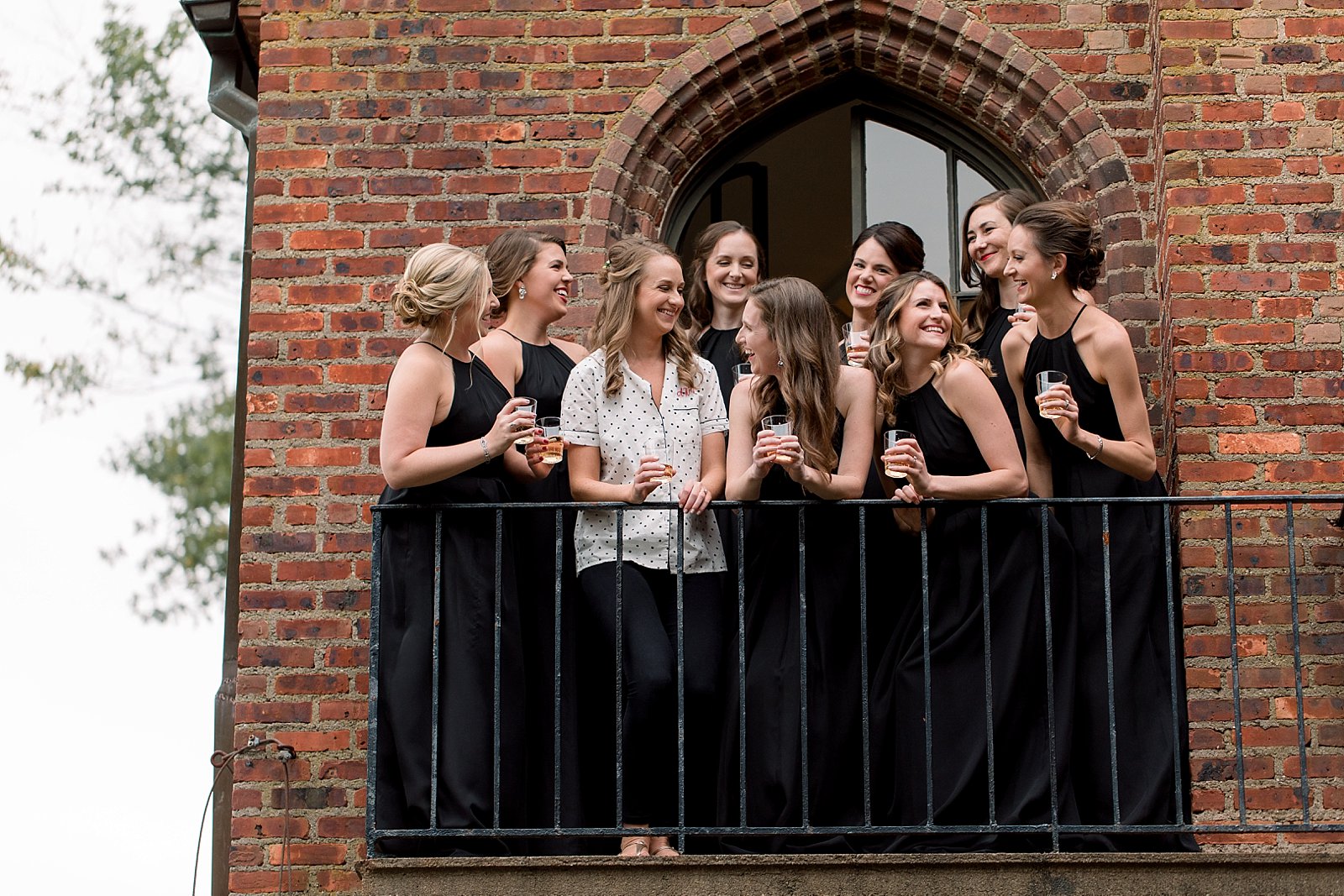 bride and bridesmaids stand on balcony at Aldie Mansion