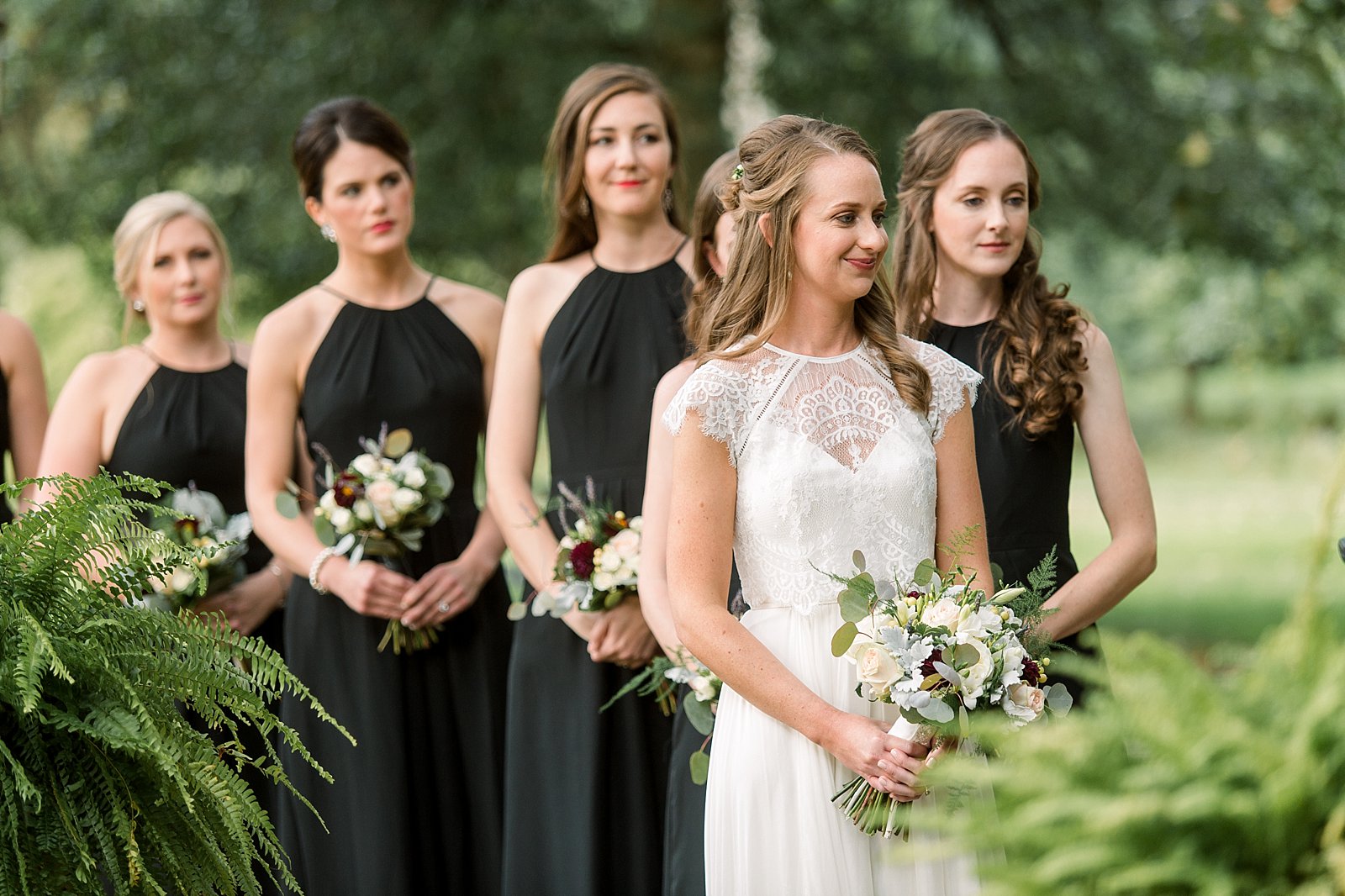 bride smiles with bridesmaids behind her for wedding ceremony at Aldie Mansion