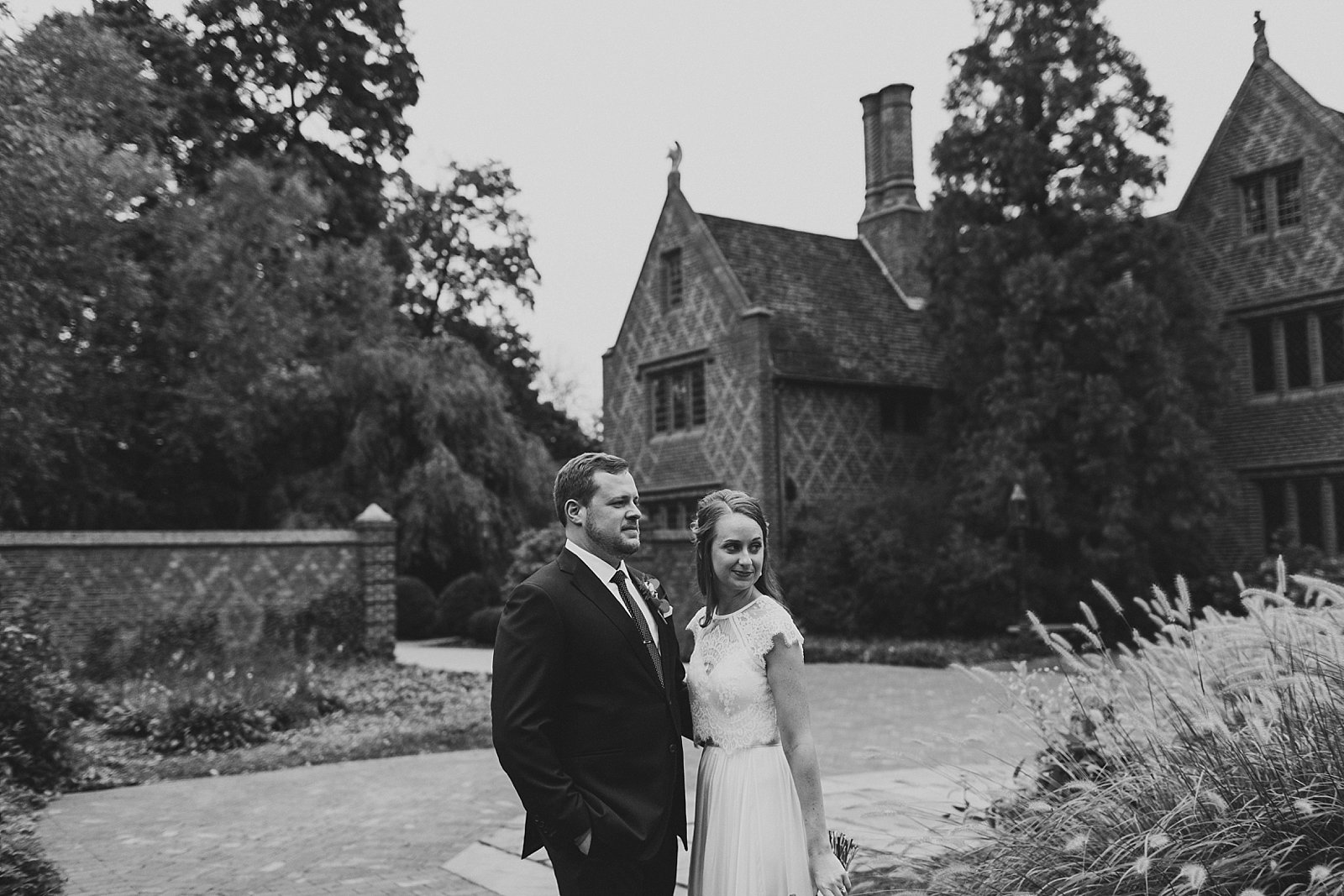 bride and groom pose in front of Aldie Mansion