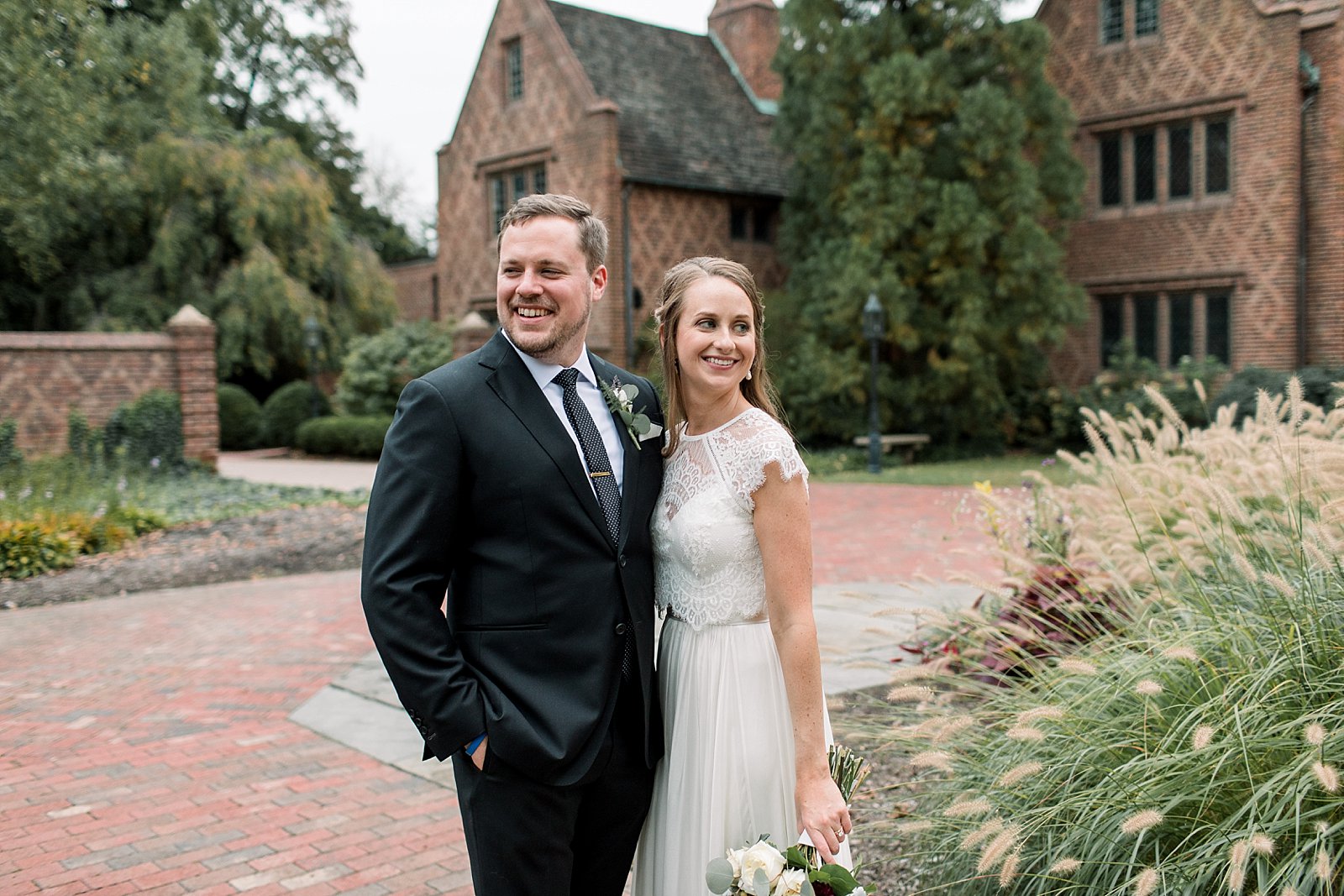 bride and groom stand on brick patio in Aldie Mansion