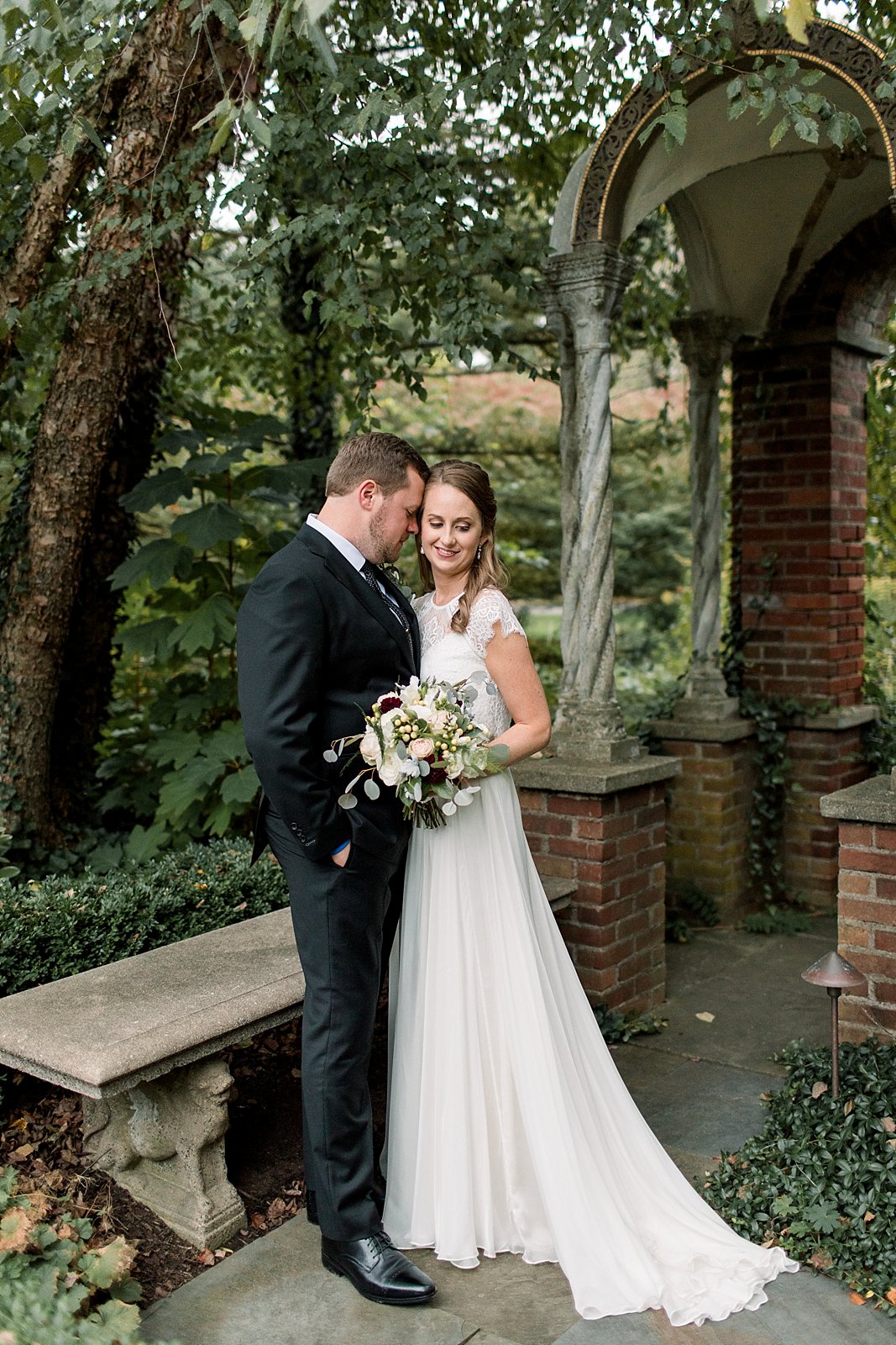 bride and groom hug in gardens at Aldie Mansion