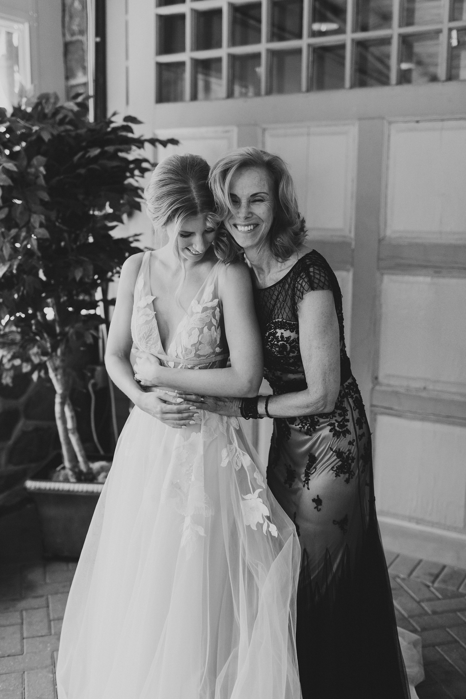 black and white photo of mother hugging bride during prep at The Carriage House at Rockwood Park