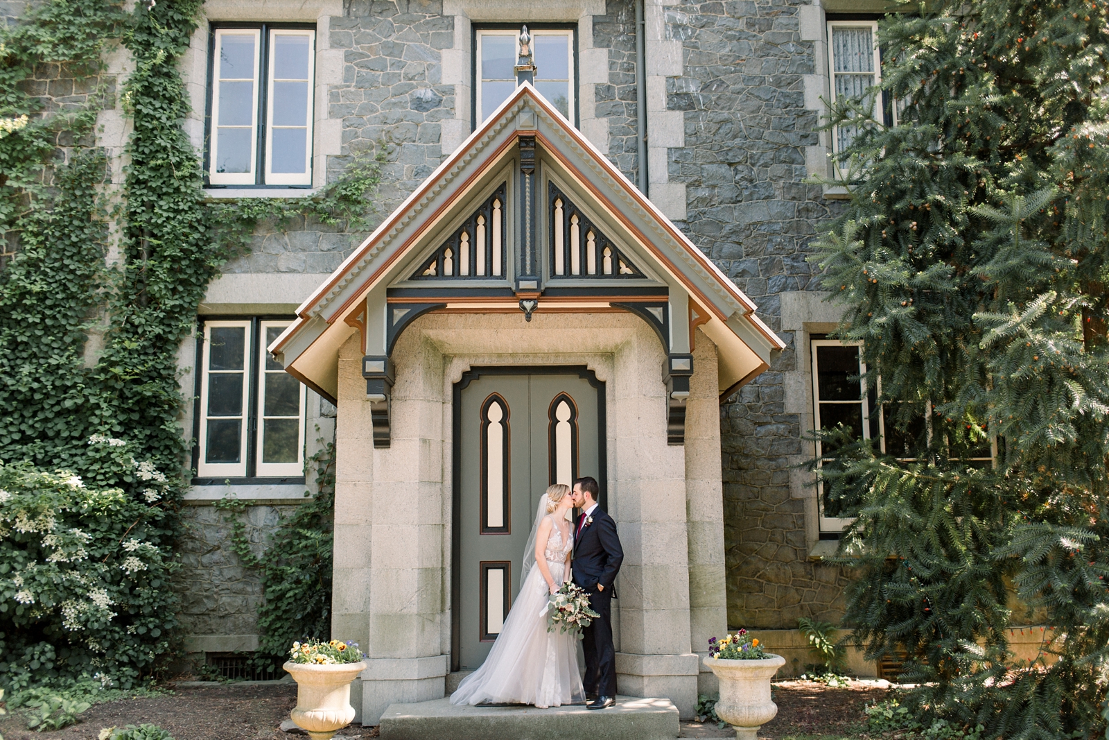 bride and groom kiss on doorstep at The Carriage House at Rockwood Park