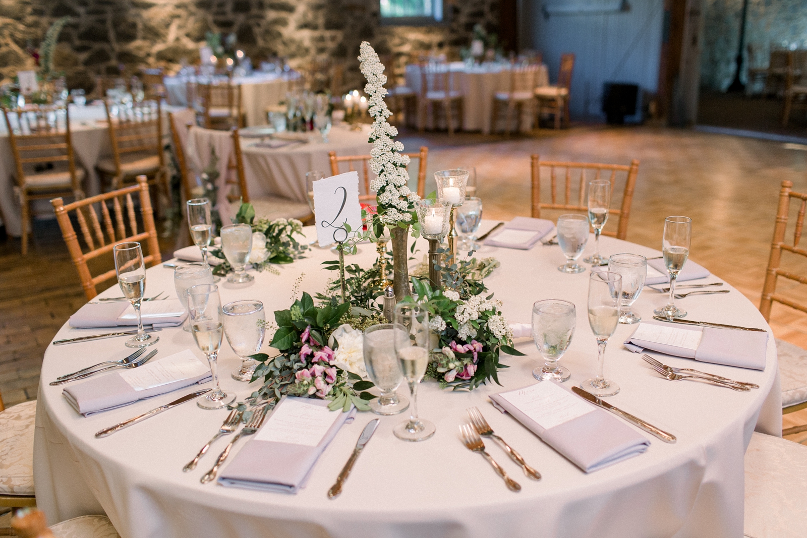 The Carriage House at Rockwood Park wedding reception with white floral centerpieces and gold vases 
