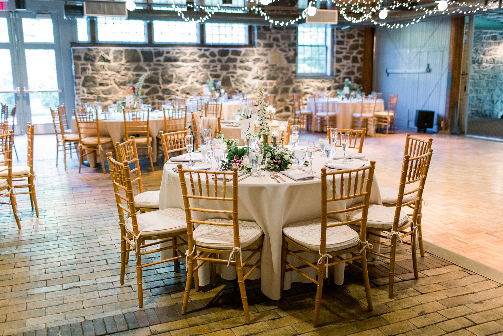 The Carriage House at Rockwood Park wedding reception with gold chivari chairs and floral centerpieces 