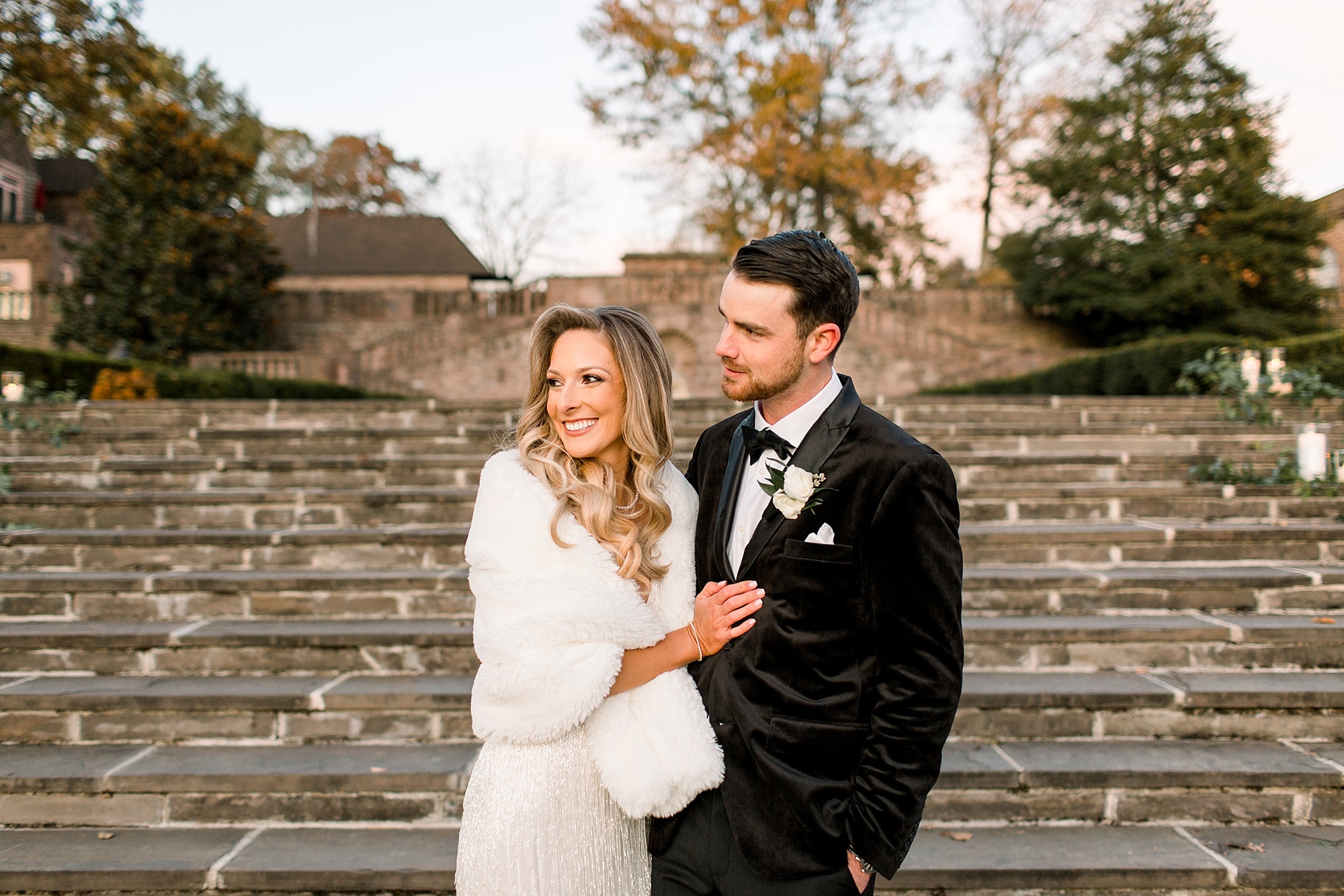 newlyweds smile in front of steps at Tyler Gardens 