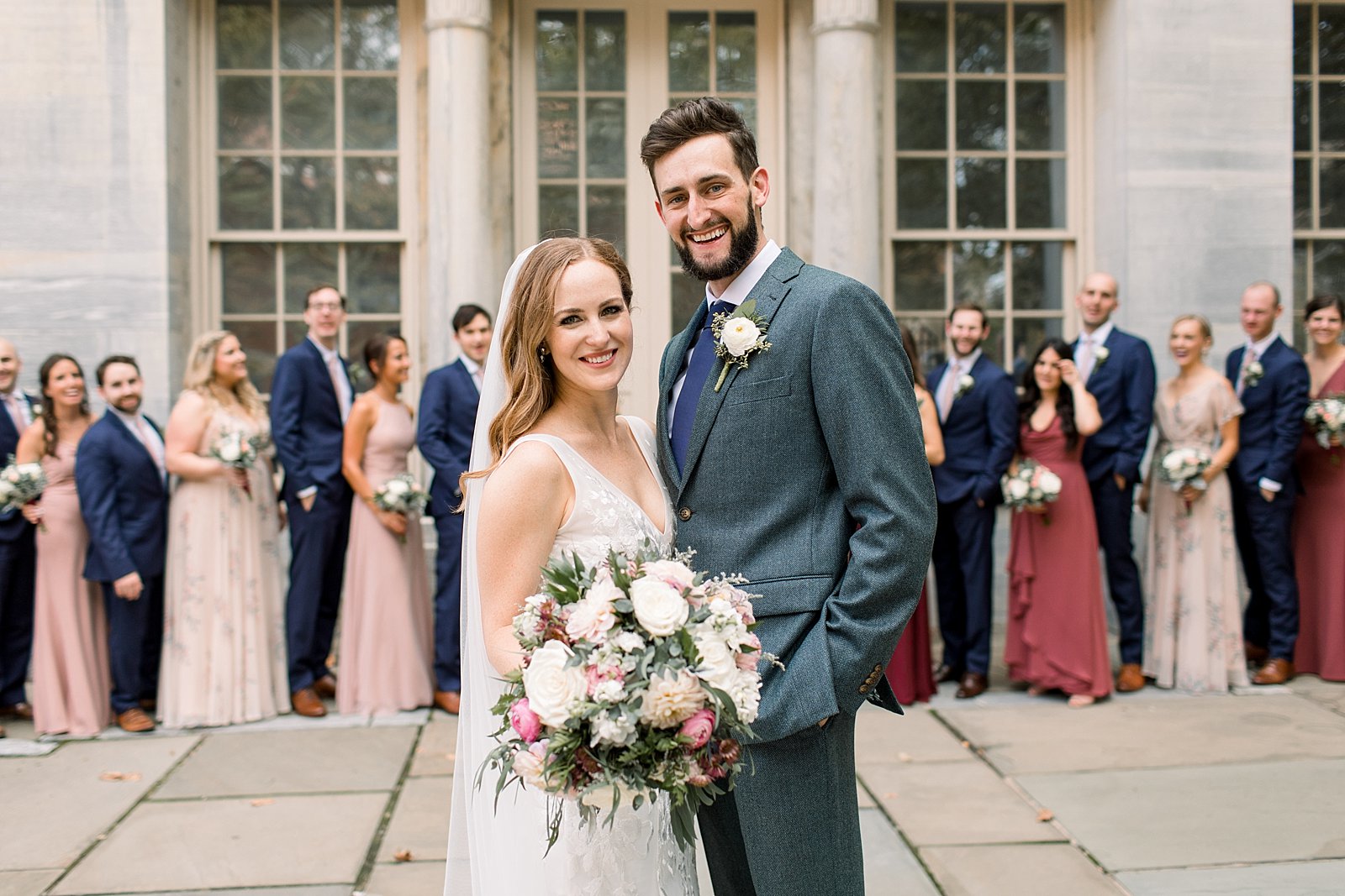 newlyweds stand in front of bridal party at the Merchant’s Exchange Building