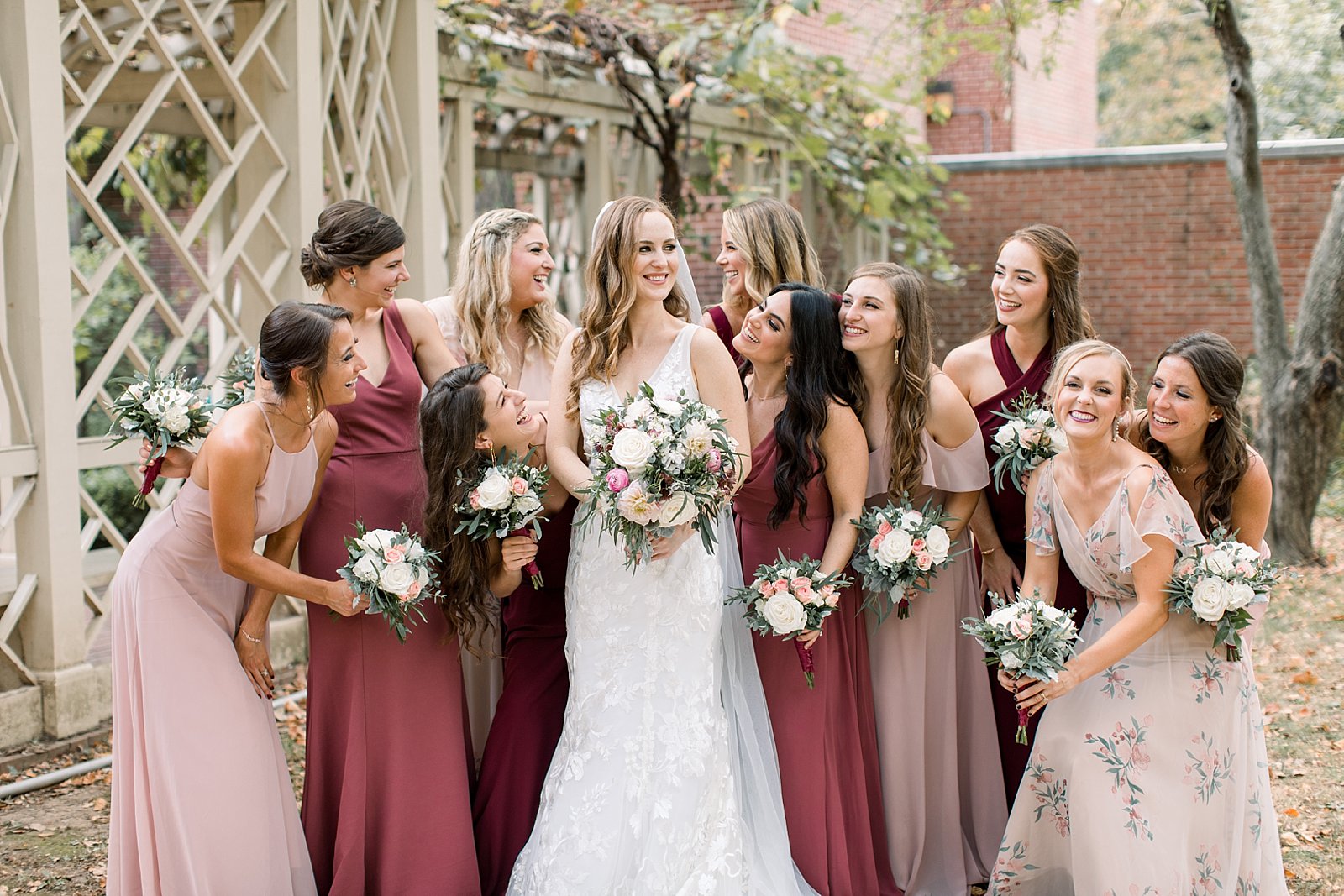 bridesmaids hug bride with pink and white bouquets at the Merchant’s Exchange Building