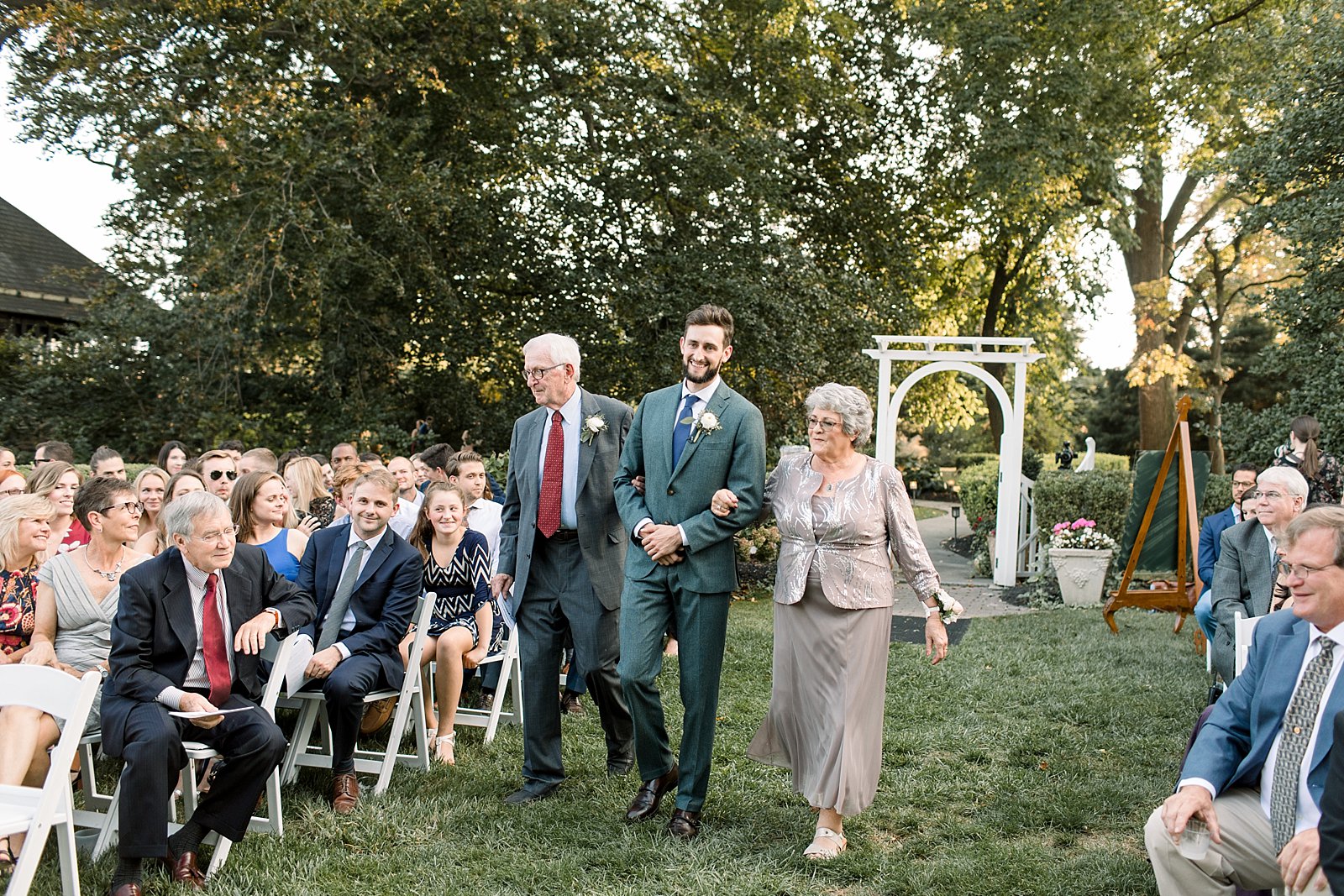 groom walks parents down aisle at Knowlton Mansion during lawn ceremony