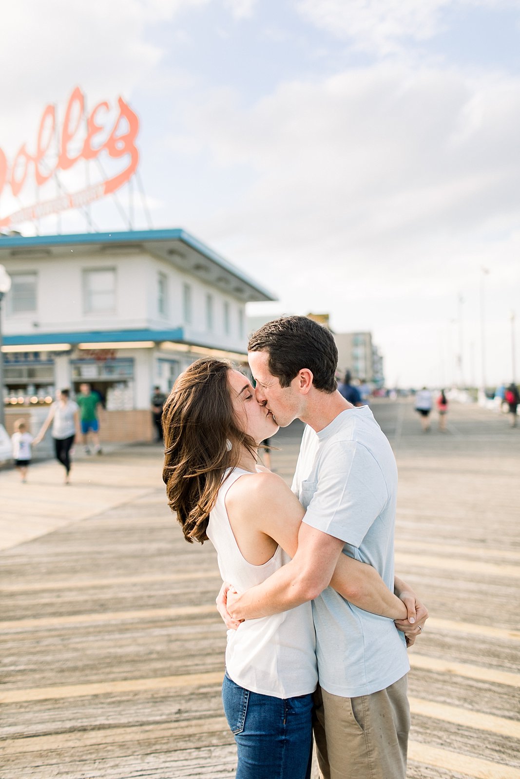bride and groom kiss on wooden boardwalk at Rehoboth Beach