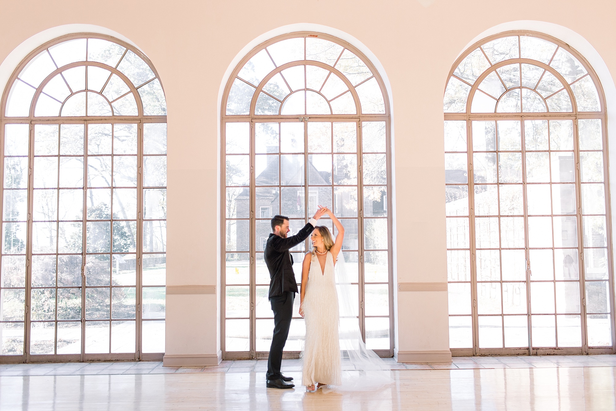 groom twirls bride in ballroom at Tyler Gardens 