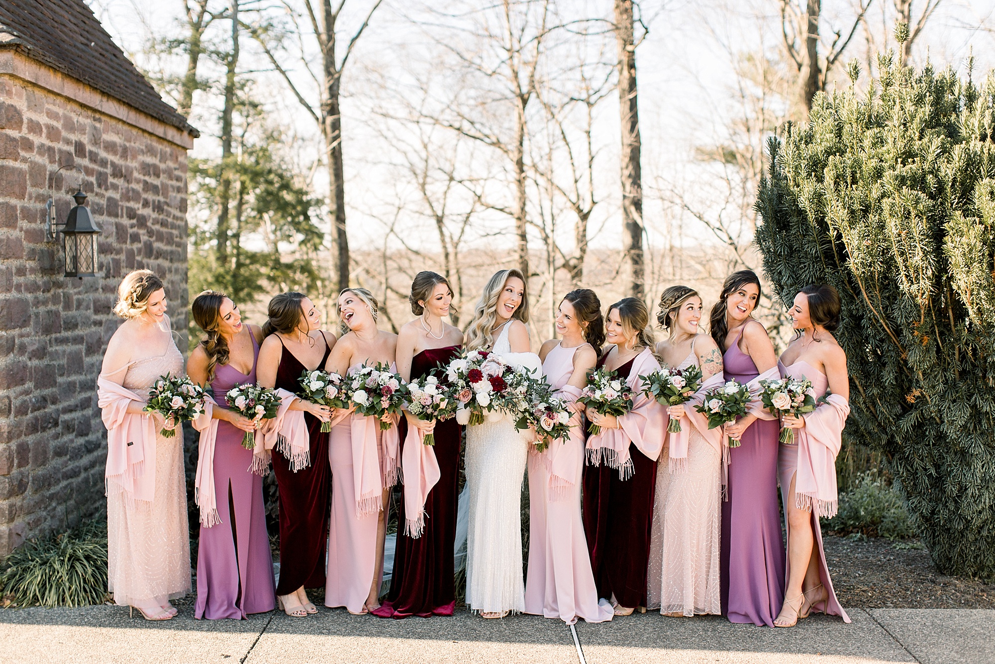 bride stands with bridesmaids in mismatched pink and purple gown at Tyler Gardens