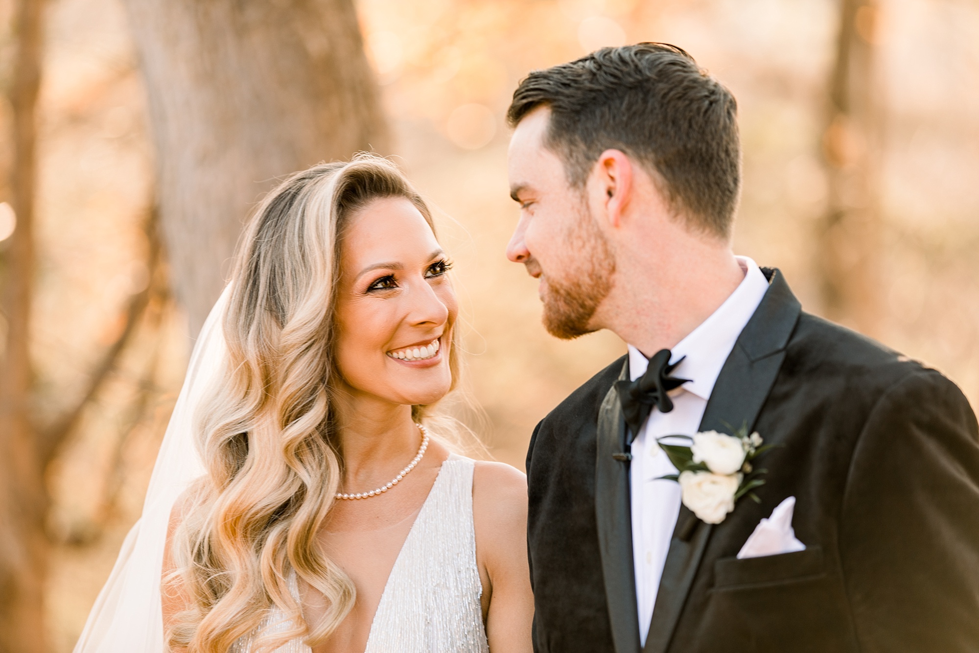 bride and groom smile together during sunset wedding photos at Tyler Gardens