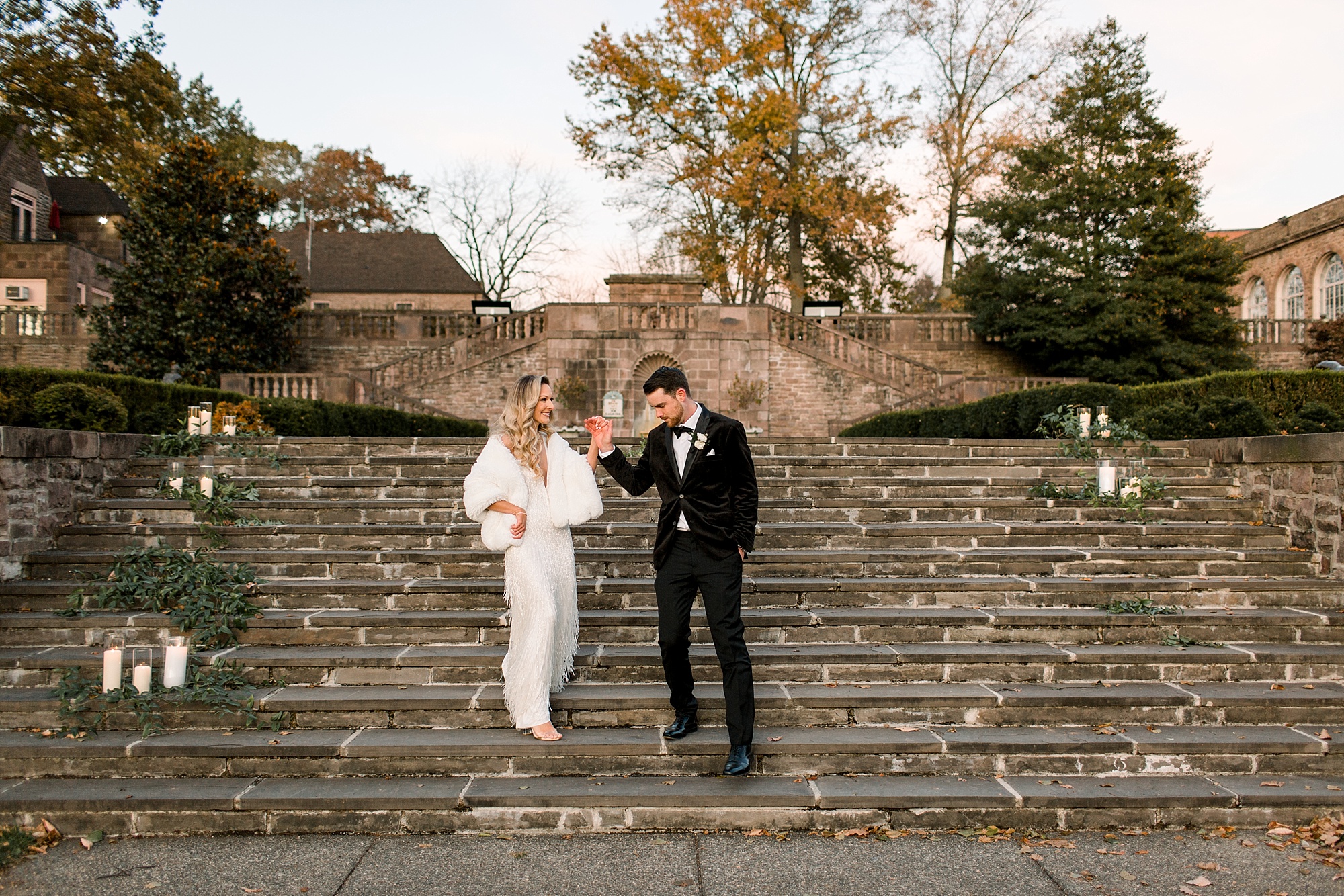 groom helps bride down steps at Tyler Gardens 