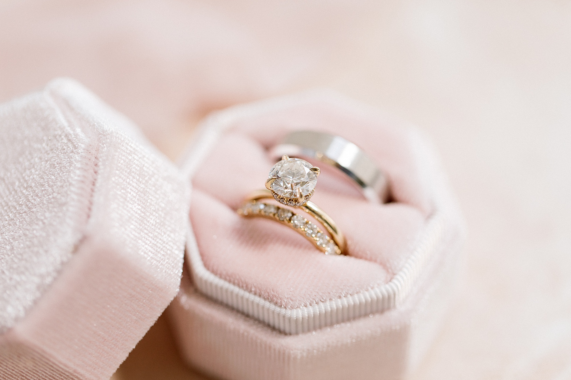 gold wedding rings rest in pink box