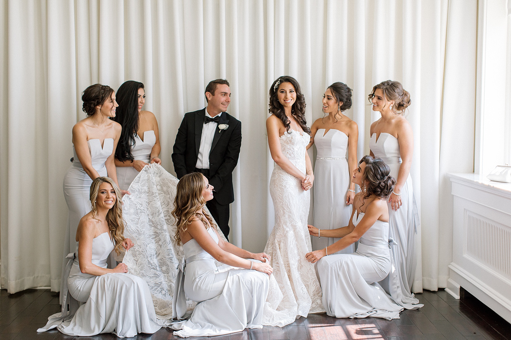 bride smiles with bridal party around her at The Ballroom at Ellis Preserve