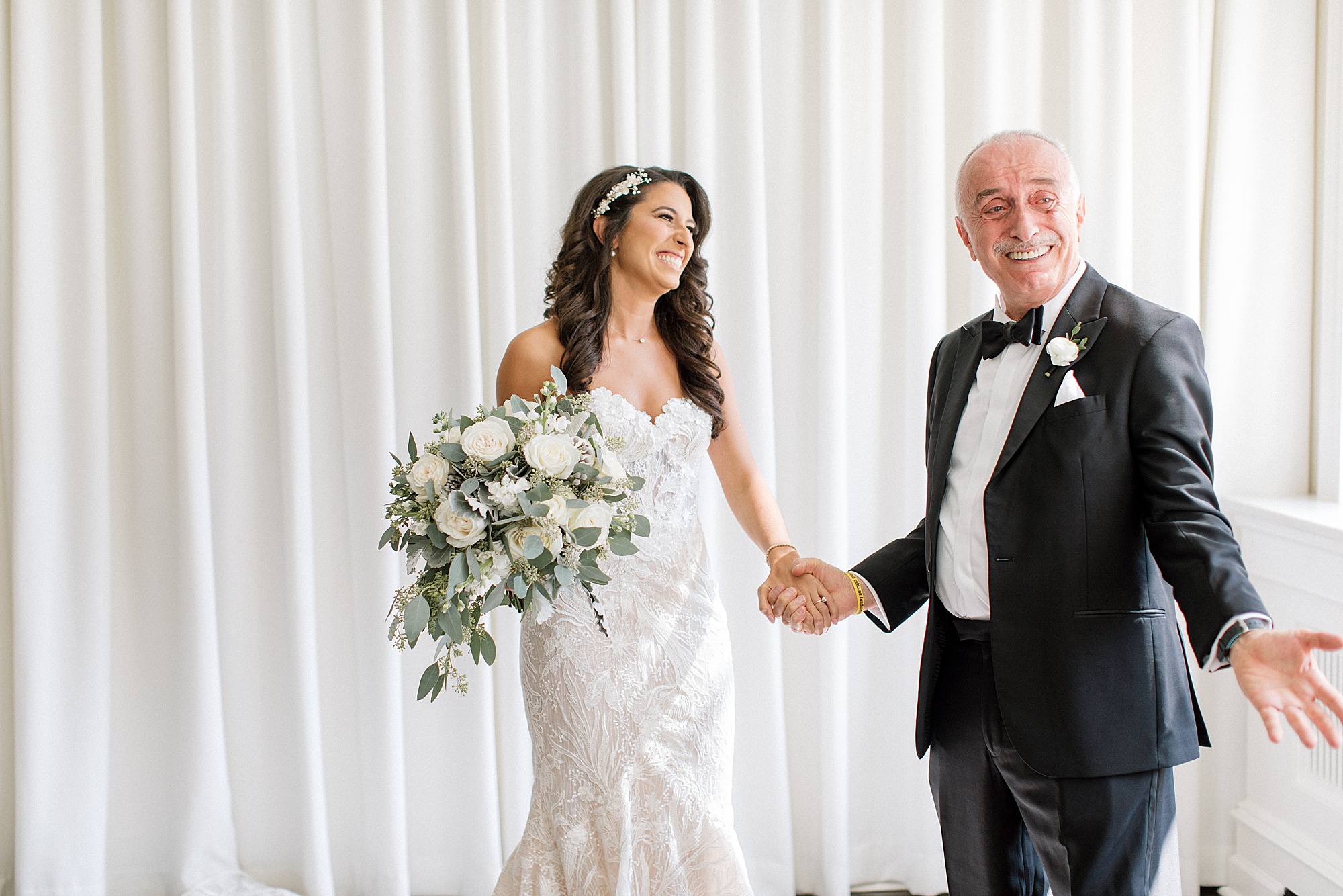 bride and dad hold hands smiling during first look at The Ballroom at Ellis Preserve