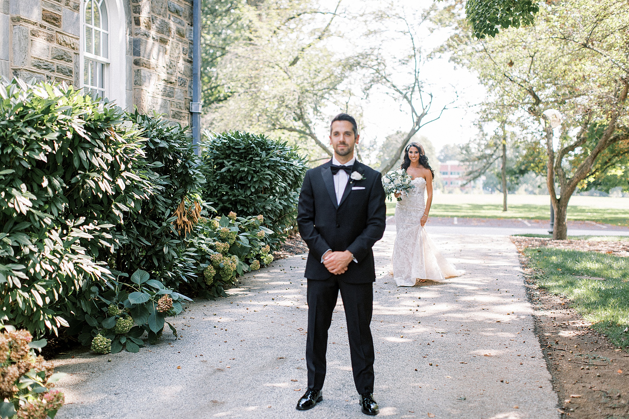 bride walks to meet groom for first look in Newton Square garden 