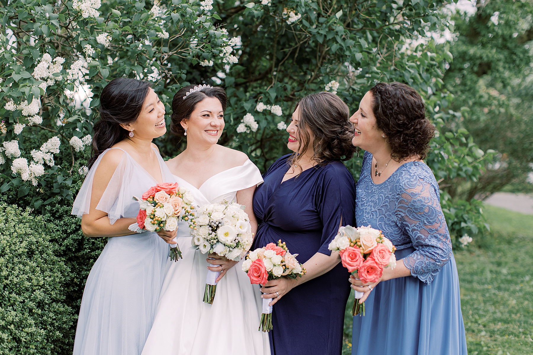 bride smiles with three bridesmaids in blue gowns at Bellevue Hall