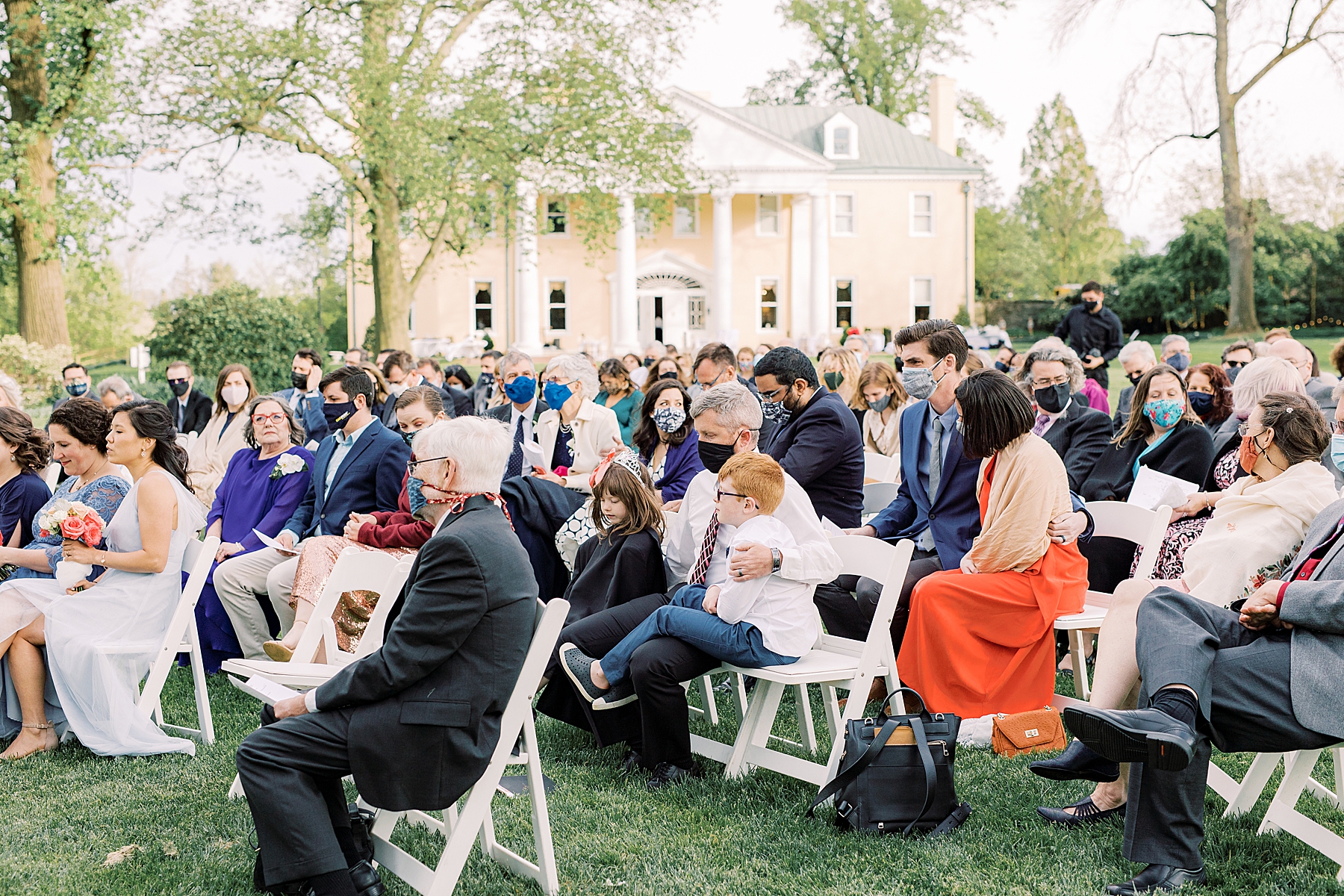 guests pray during wedding ceremony on lawn at Bellevue Hall