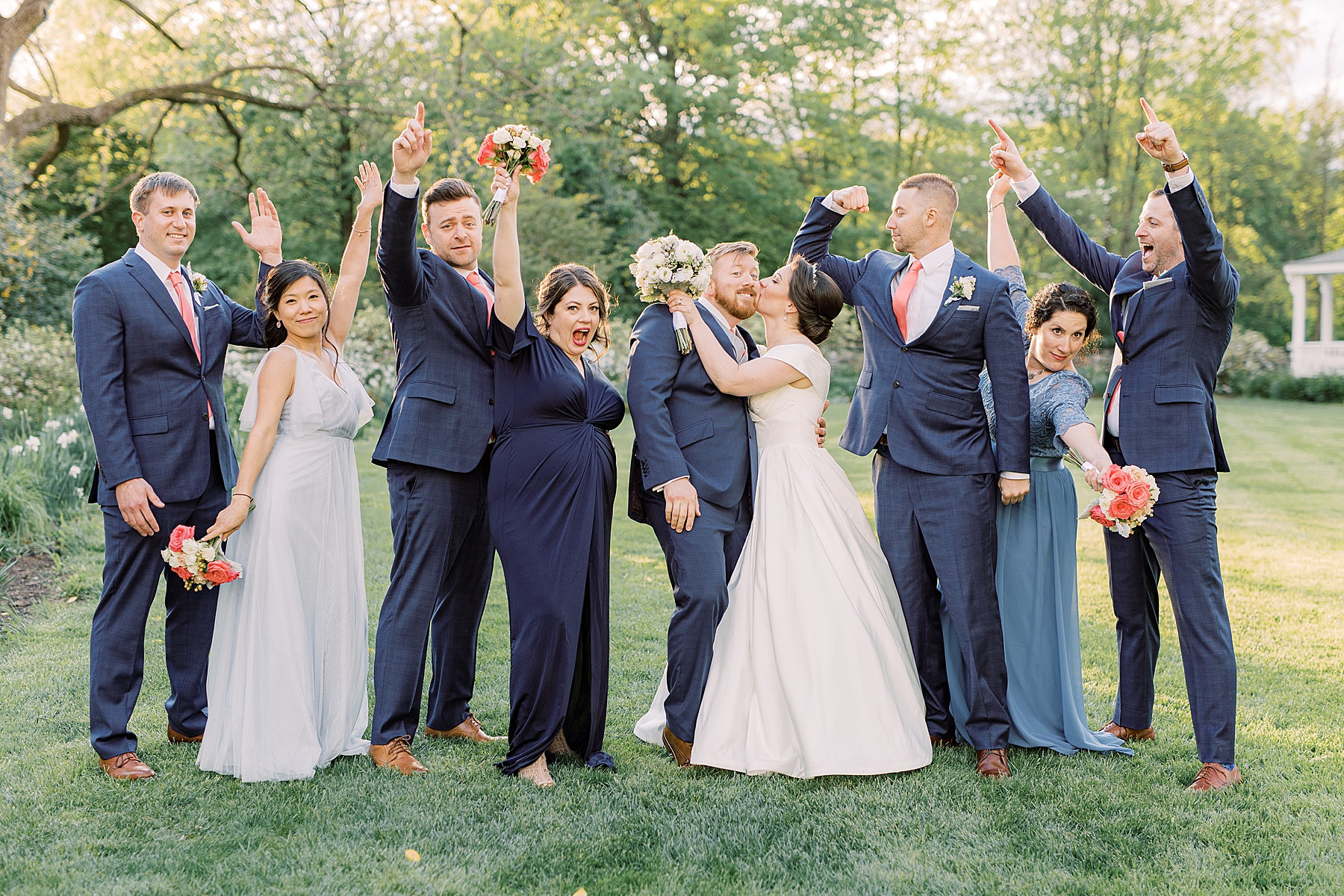 wedding party laughs and cheers around bride and groom