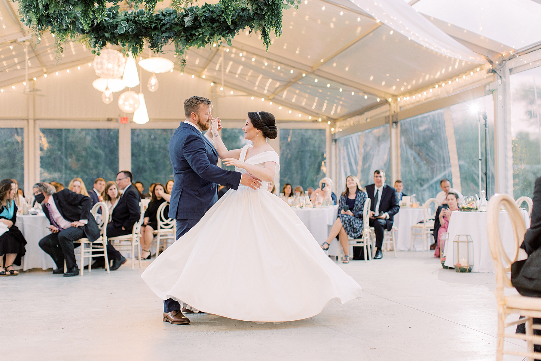 groom twirls bride on dance floor at Bellevue Hall wedding reception