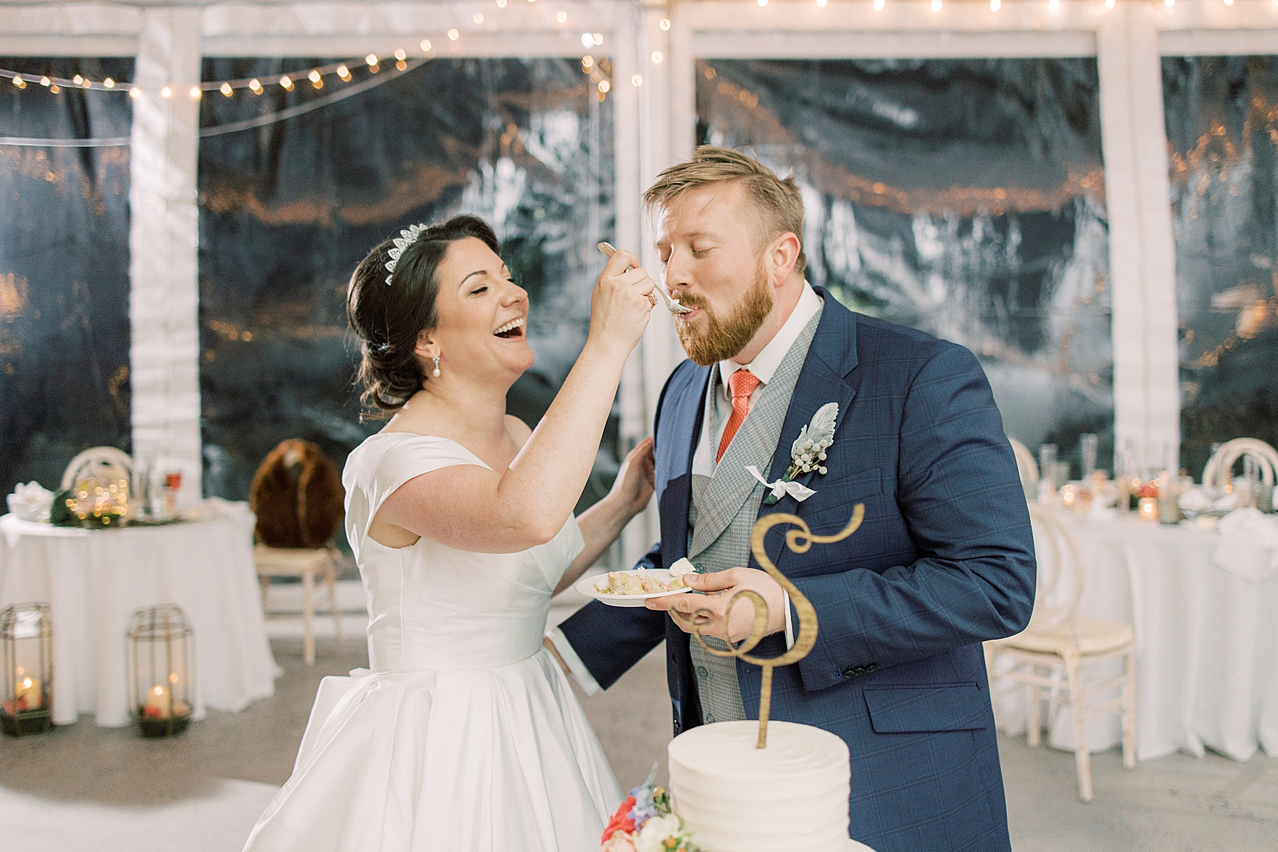 bride feeds groom cake during Bellevue Hall wedding reception