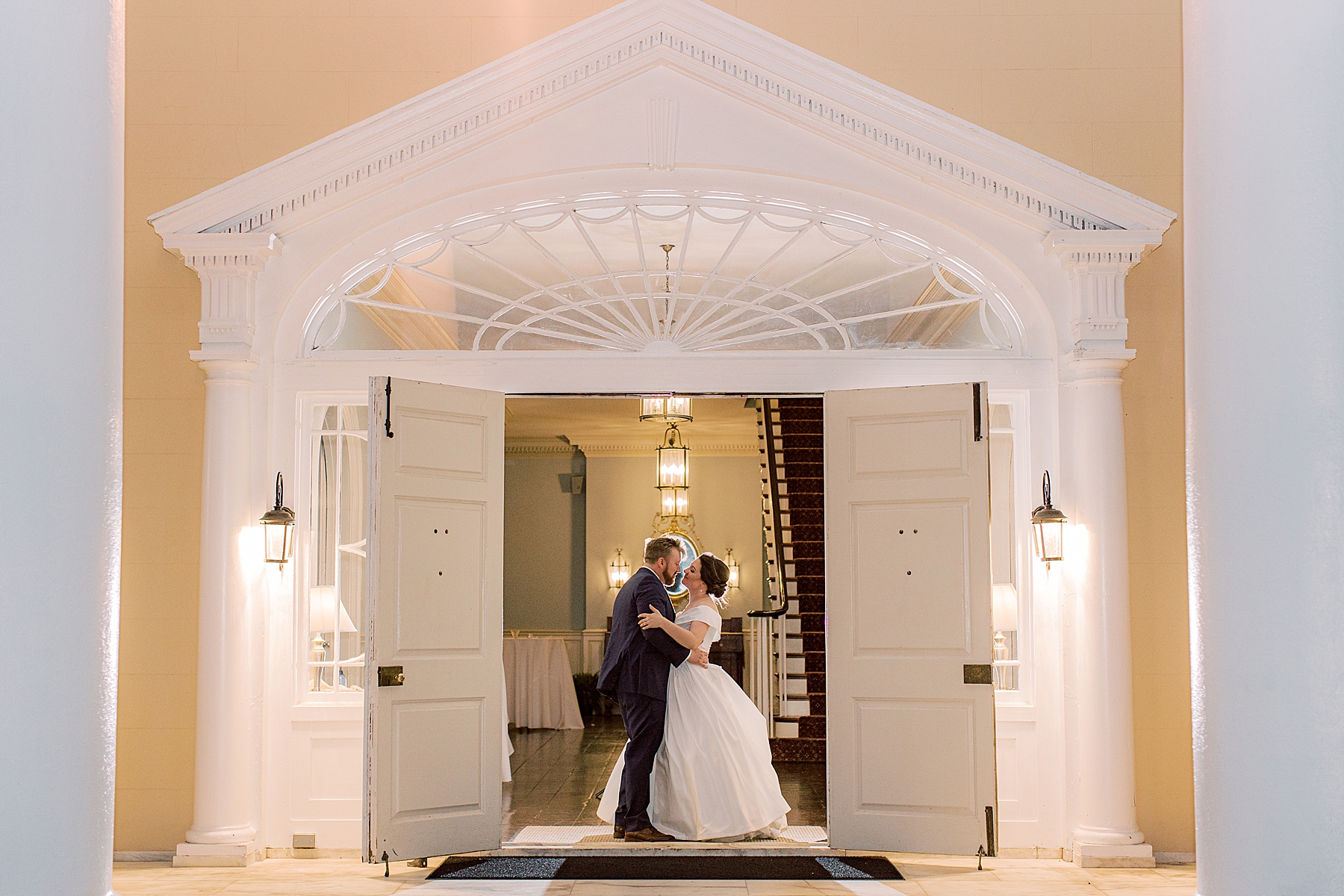 newlyweds kiss in doorway at Bellevue Hall 