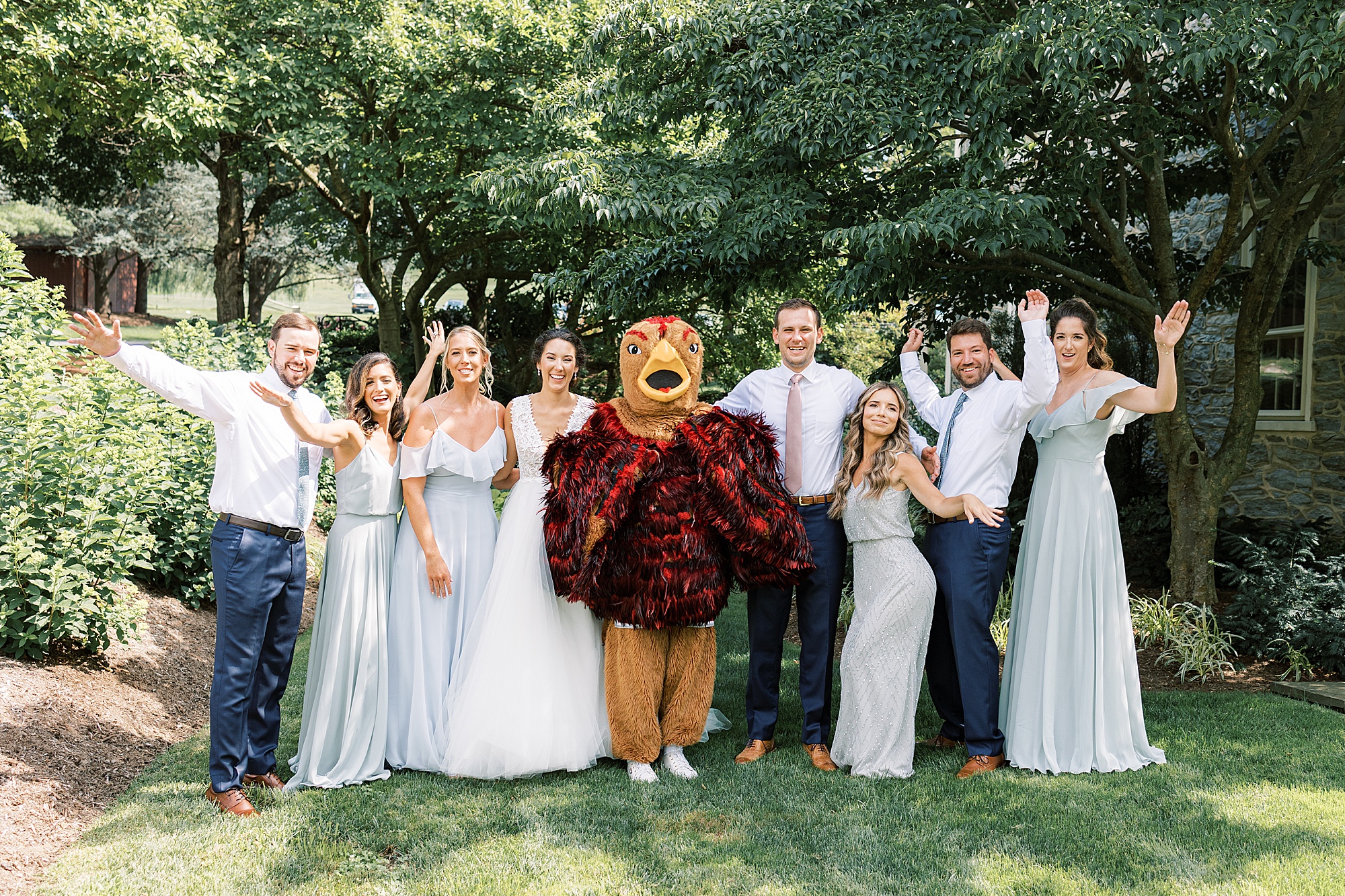 bride and groom cheer with mascot 