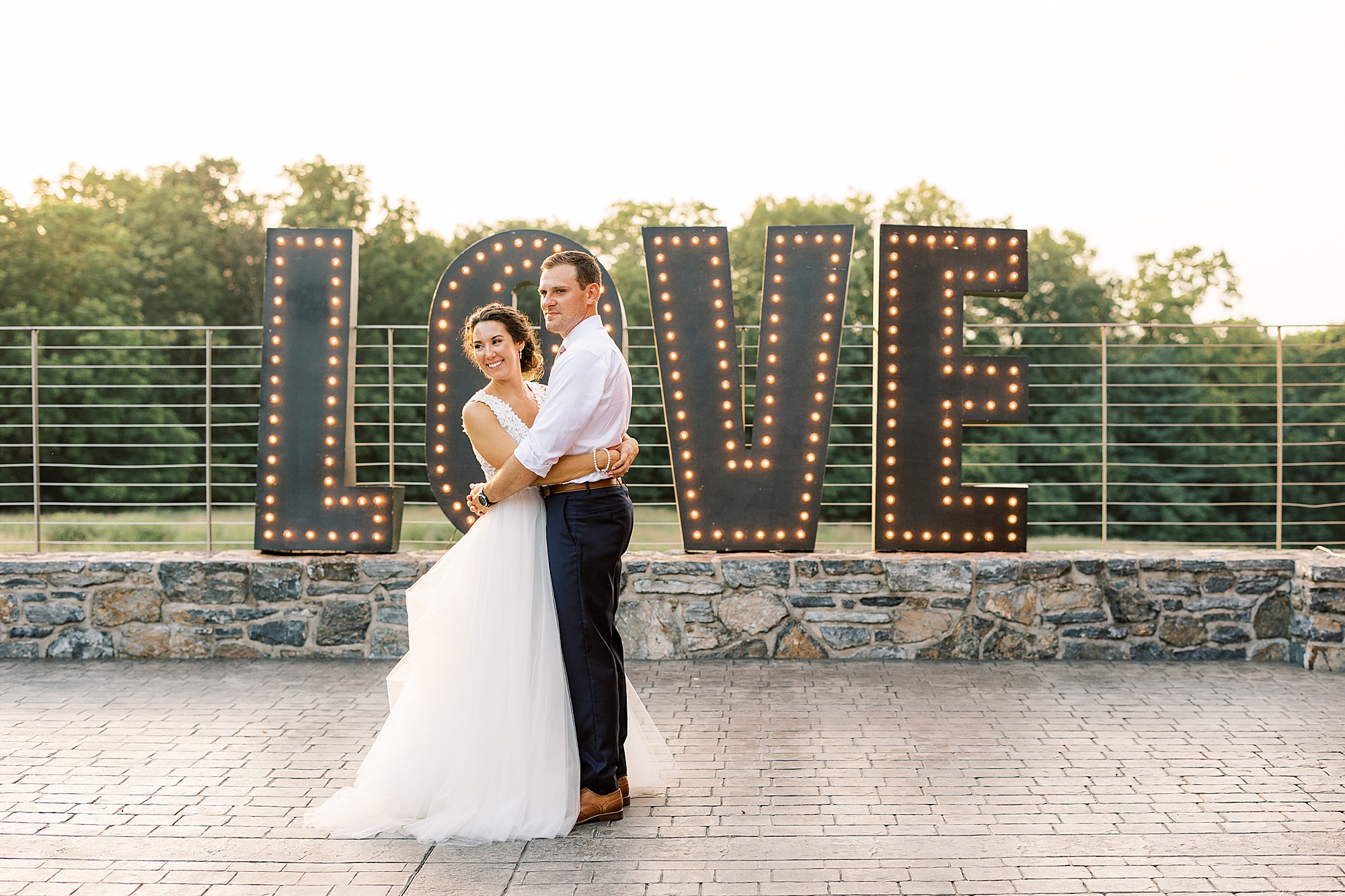 bride and groom hug in front of LOVE sign at Lancaster PA wedding reception