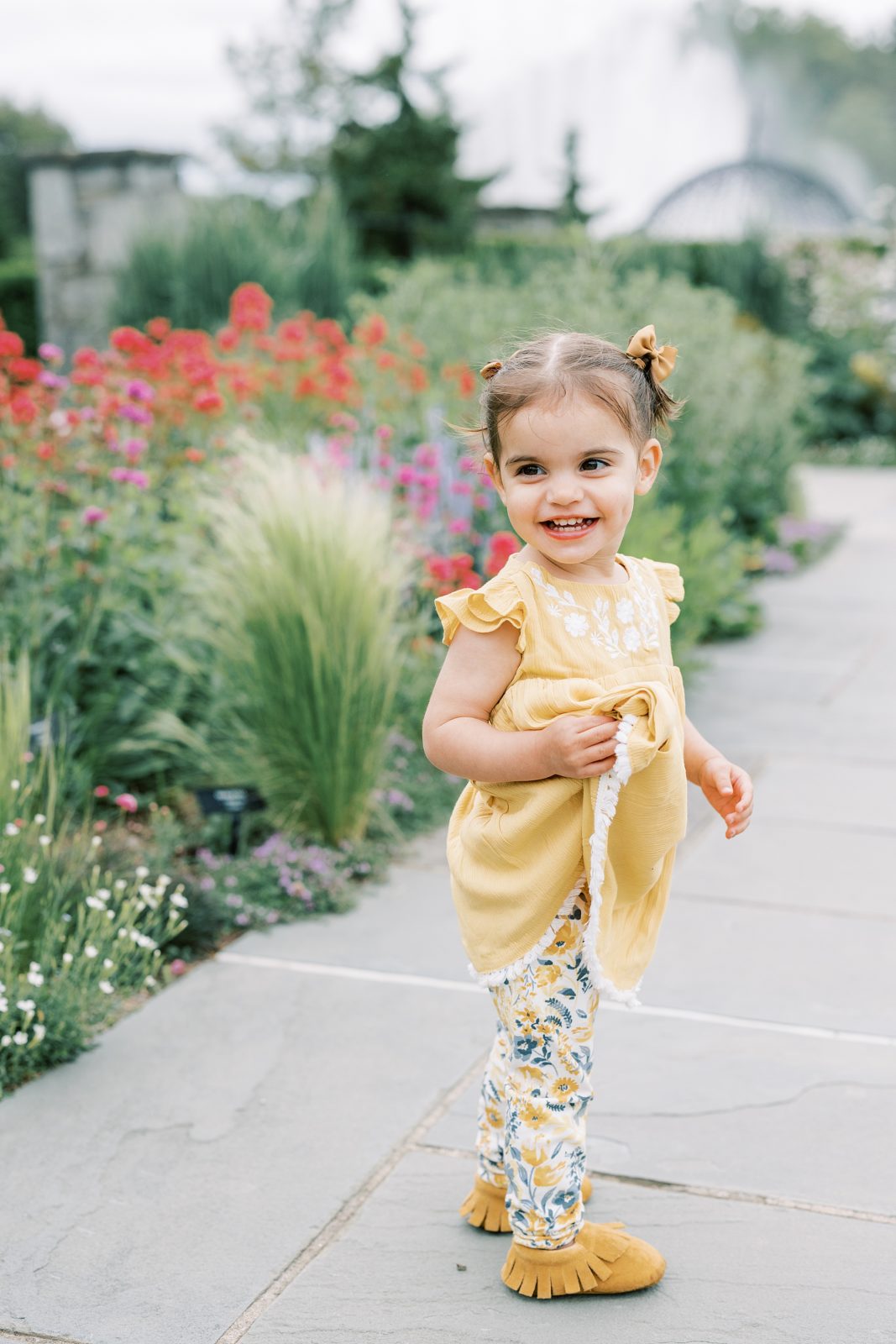 little girl with pigtails in yellow dress in Media PA garden 