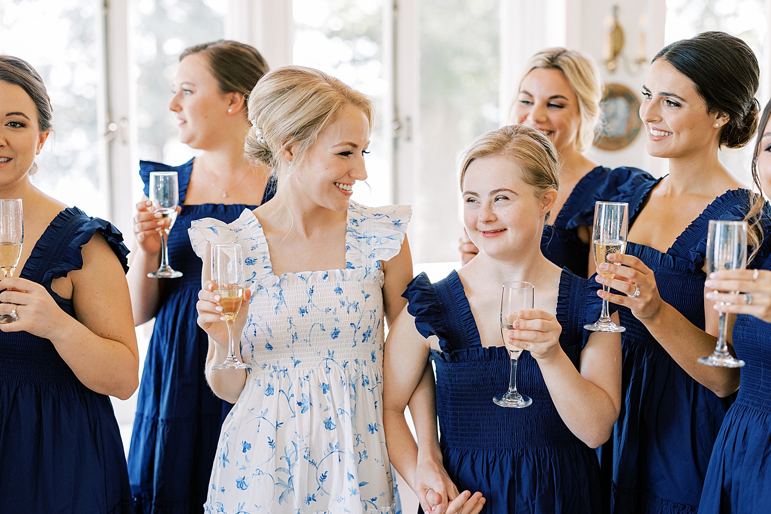 bride and bridesmaids hold glass of Champagne before Philly wedding 