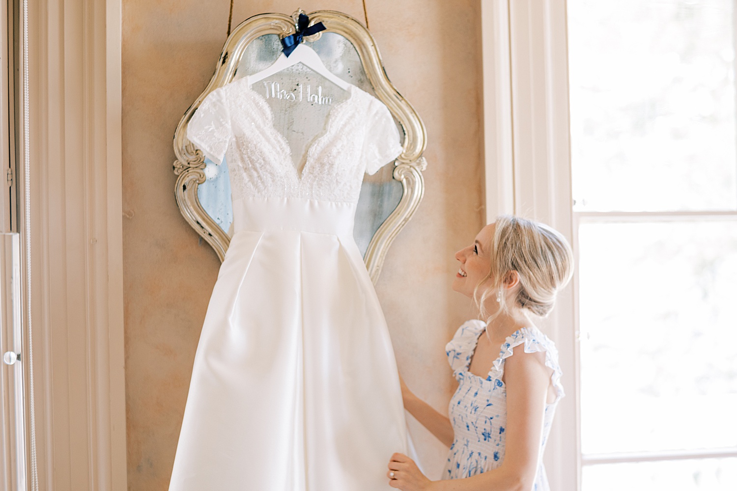 bride looks up at wedding gown with classic cap sleeves 
