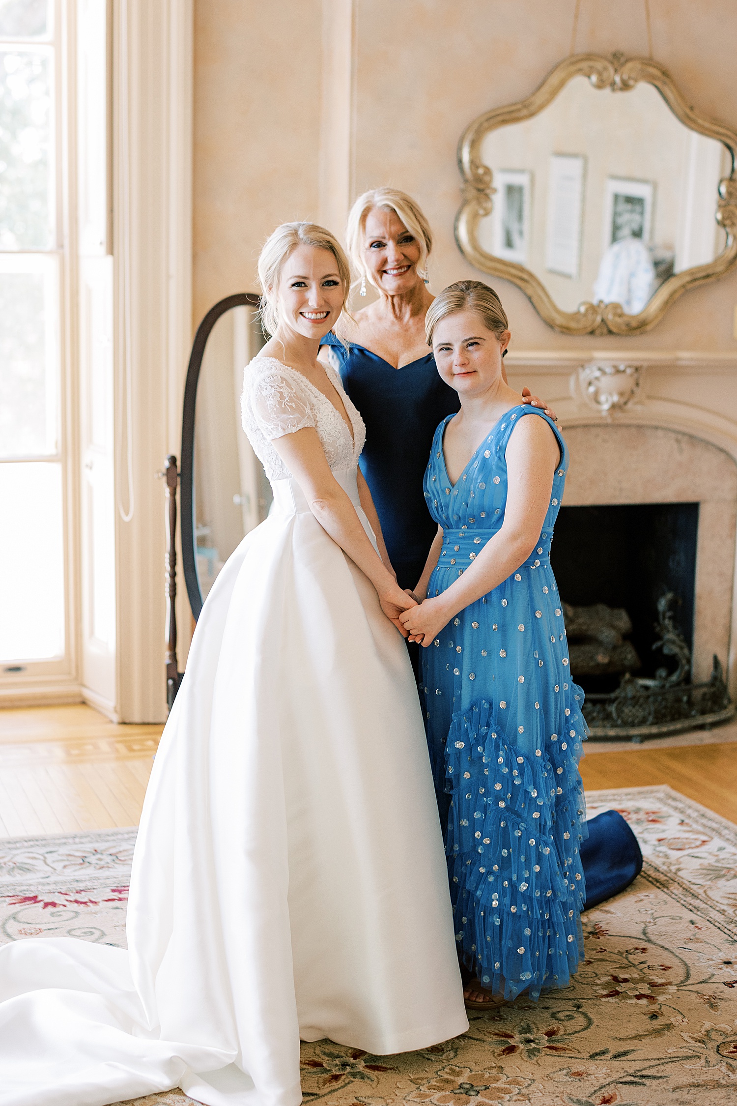 bride poses with mother and sister in blue and silver dress at Glen Foerd on the Delaware