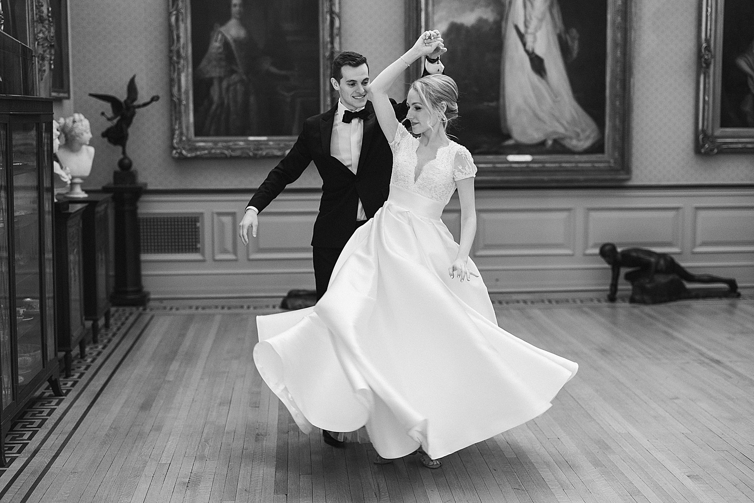 groom twirls bride inside art gallery at Glen Foerd on the Delaware