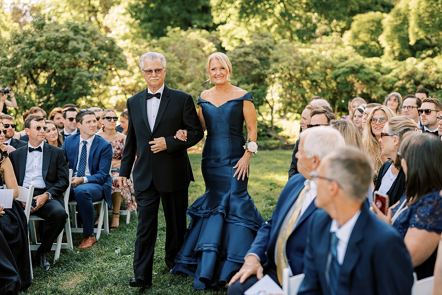 parents walk down aisle during Philadelphia wedding ceremony in the garden at Glen Foerd on the Delaware