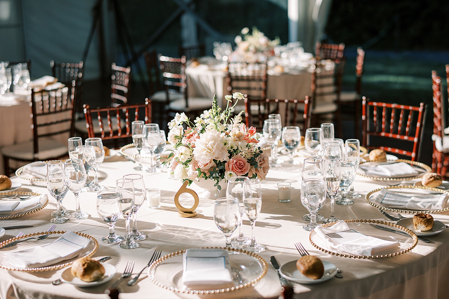 circle table with gold rimmed plates and pink floral centerpiece at Glen Foerd on the Delaware