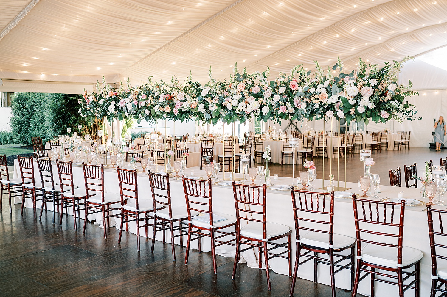 family style seating with tall rose centerpieces under tent at Glen Foerd on the Delaware
