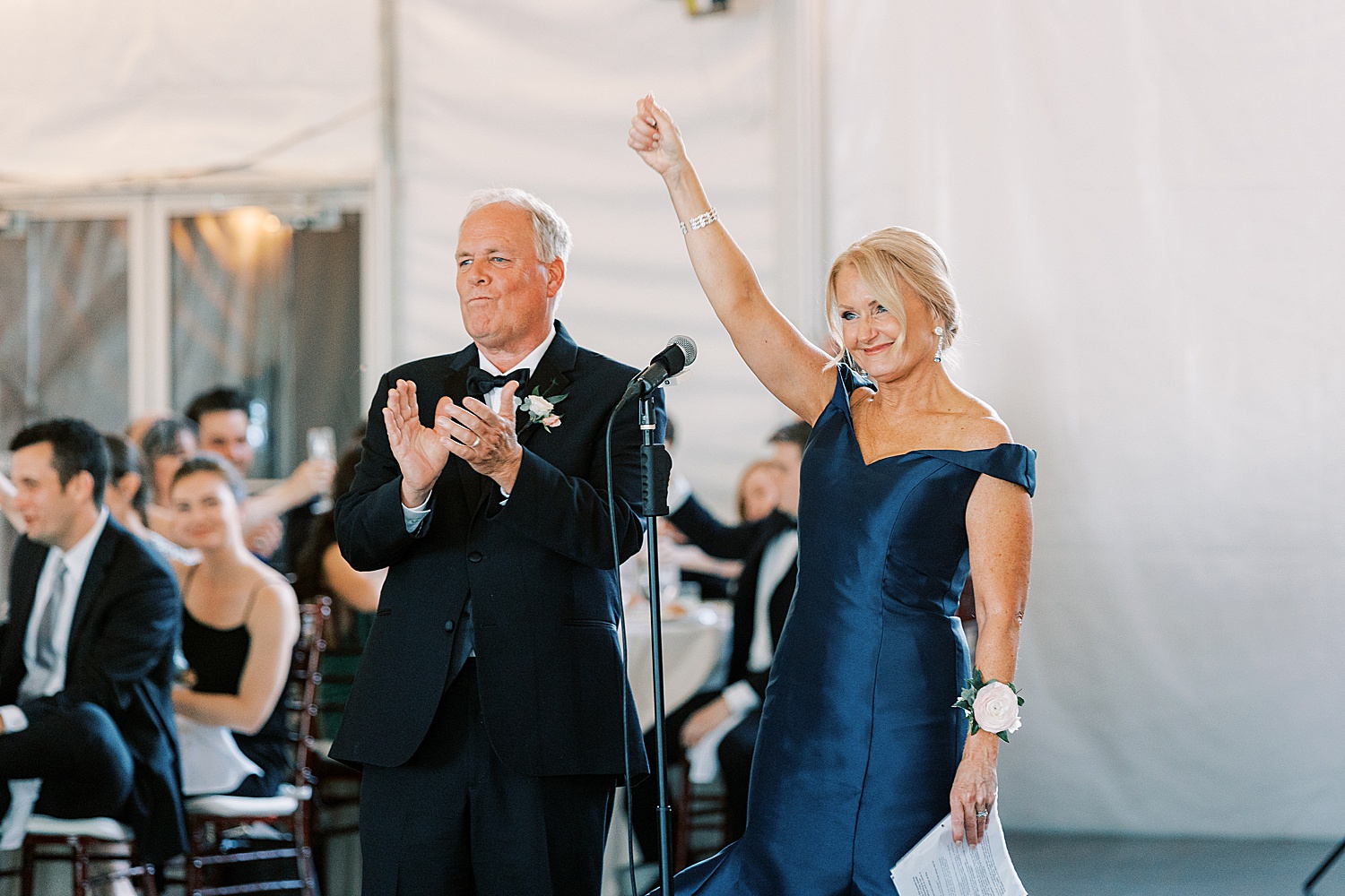 mom lifts hand in the air during toast at Philadelphia PA wedding reception