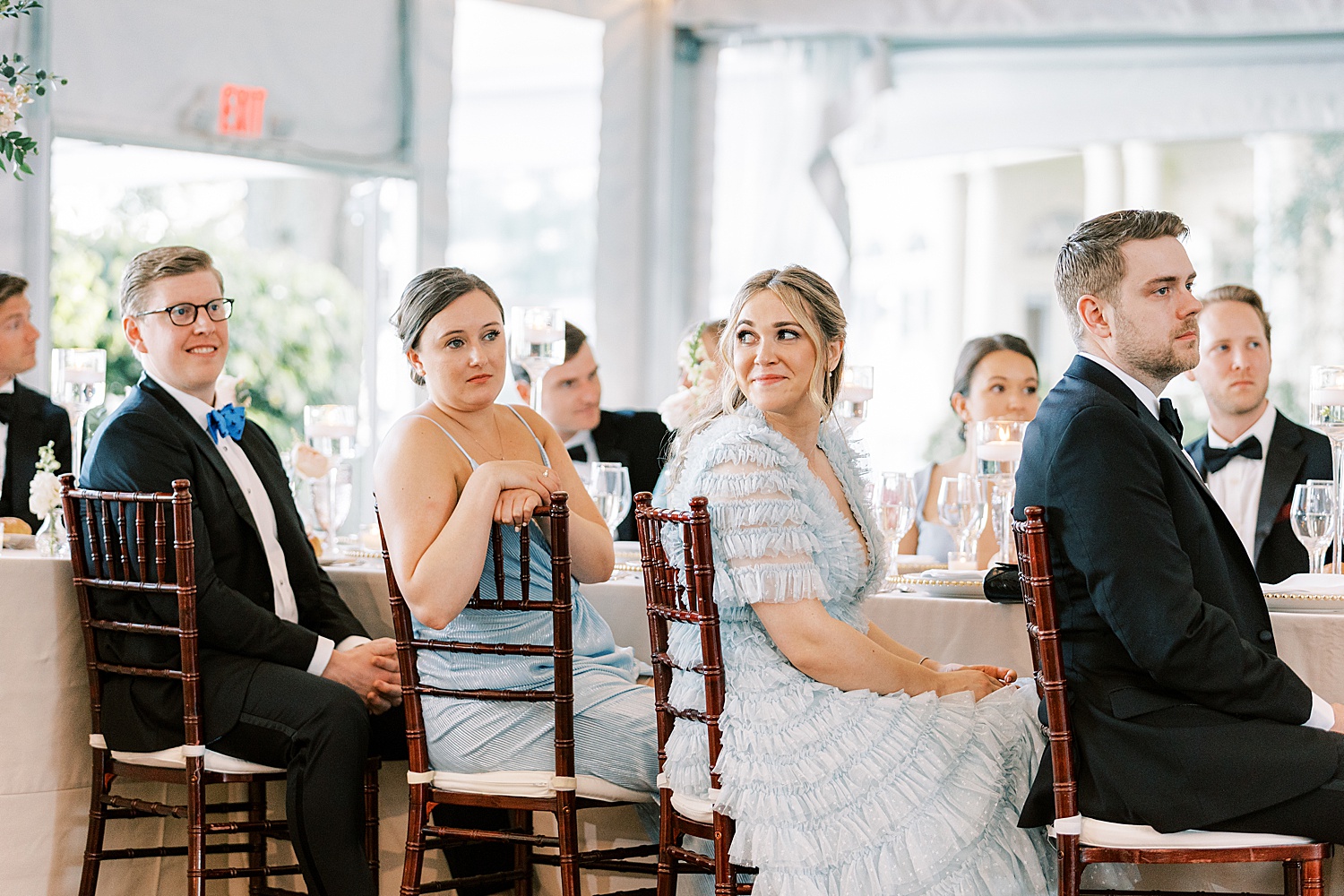 bridesmaids listen to toast during wedding reception 