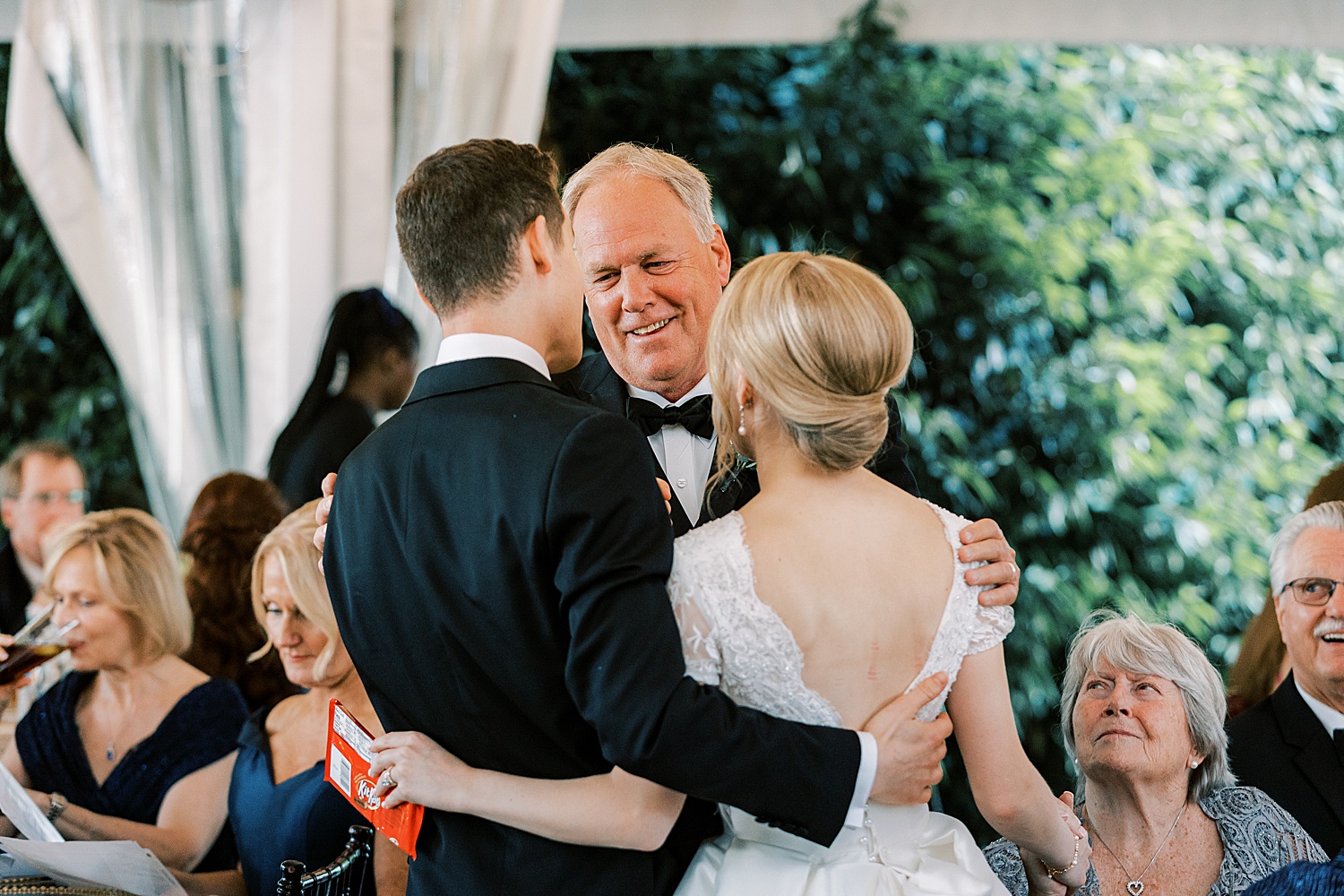 father hugs bride and groom during Philadelphia PA wedding reception