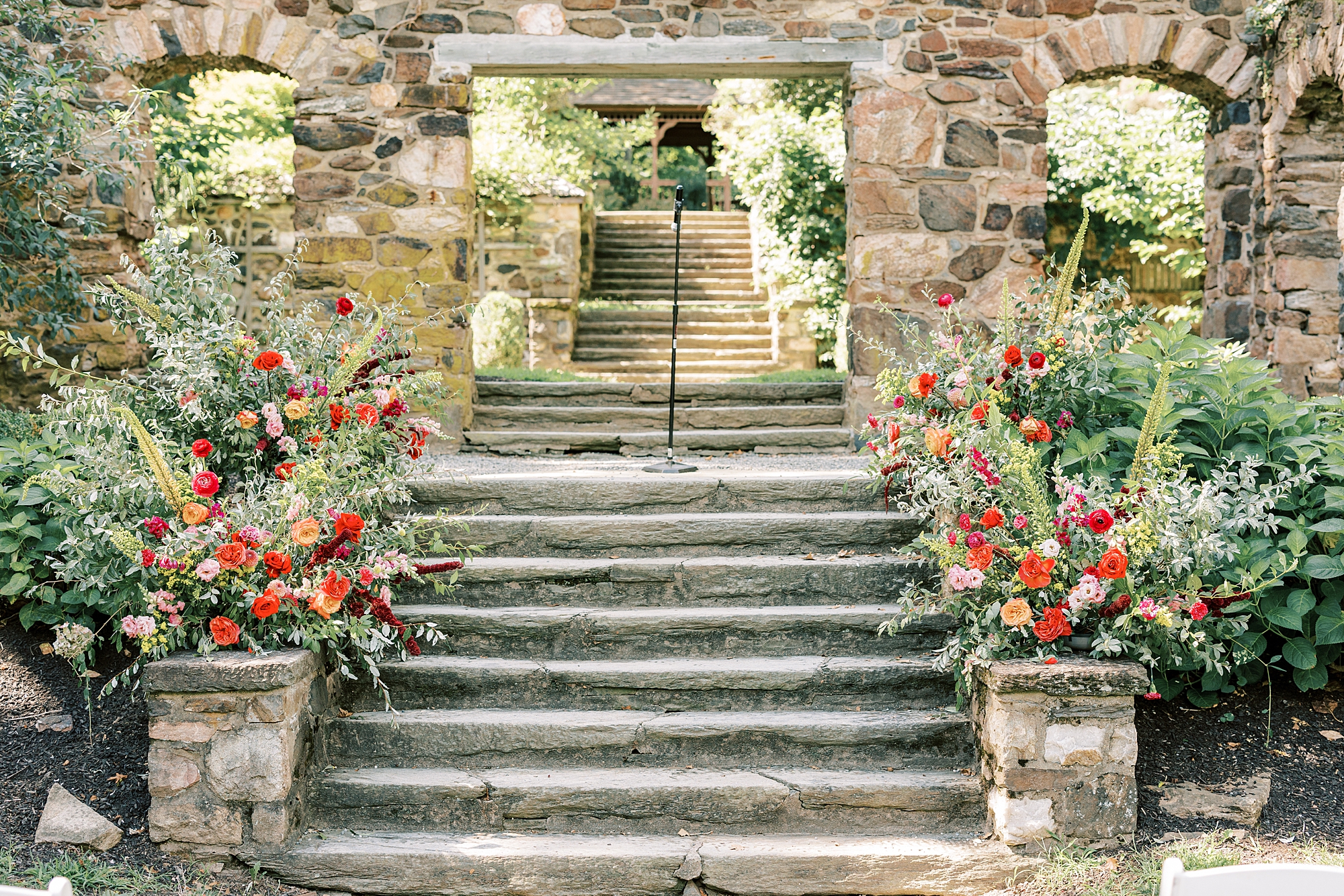 summer wedding ceremony in stone arch of gardens at Parque Ridley Creek