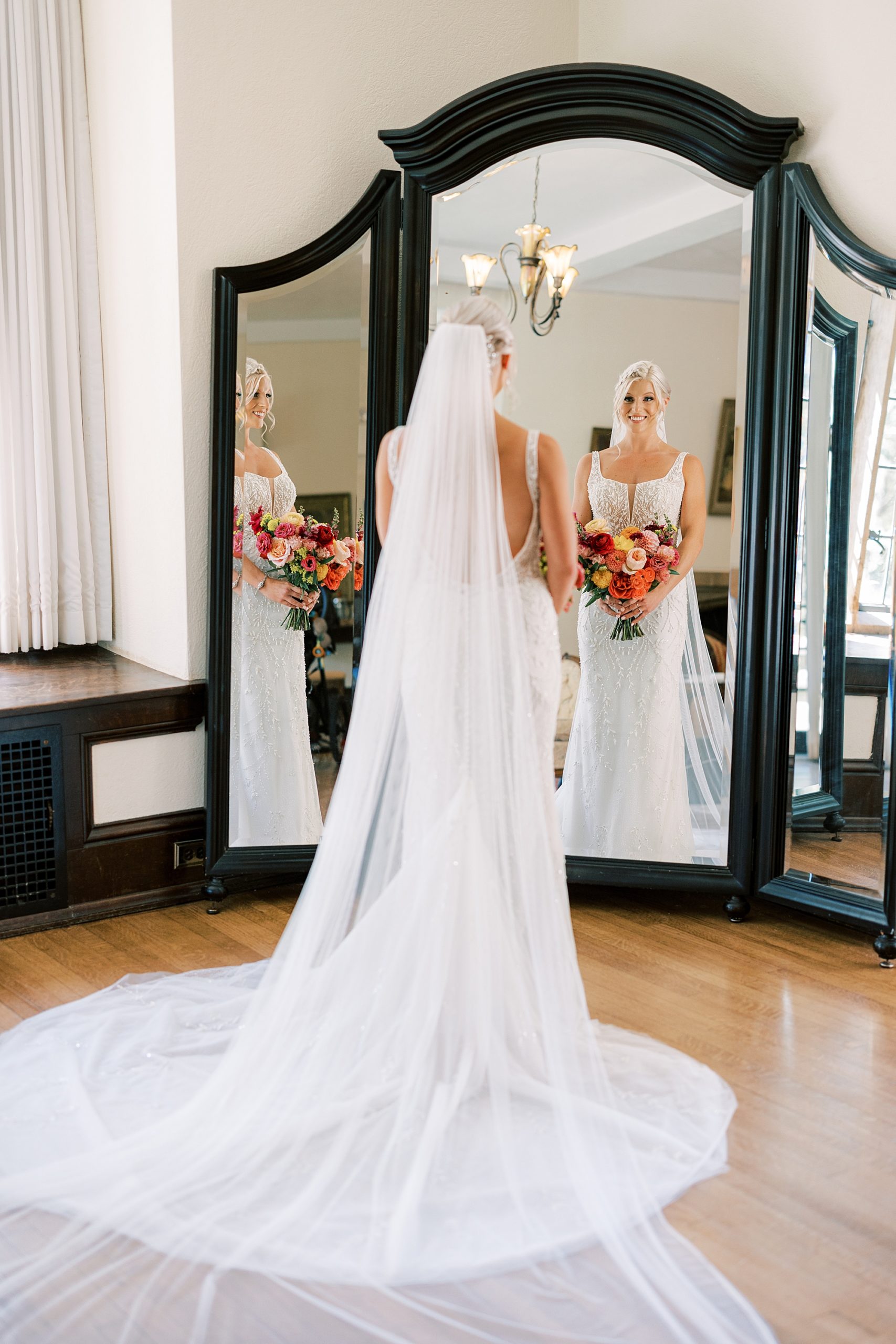 bride stands looking in mirror in bridal suite at Parque Ridley Creek