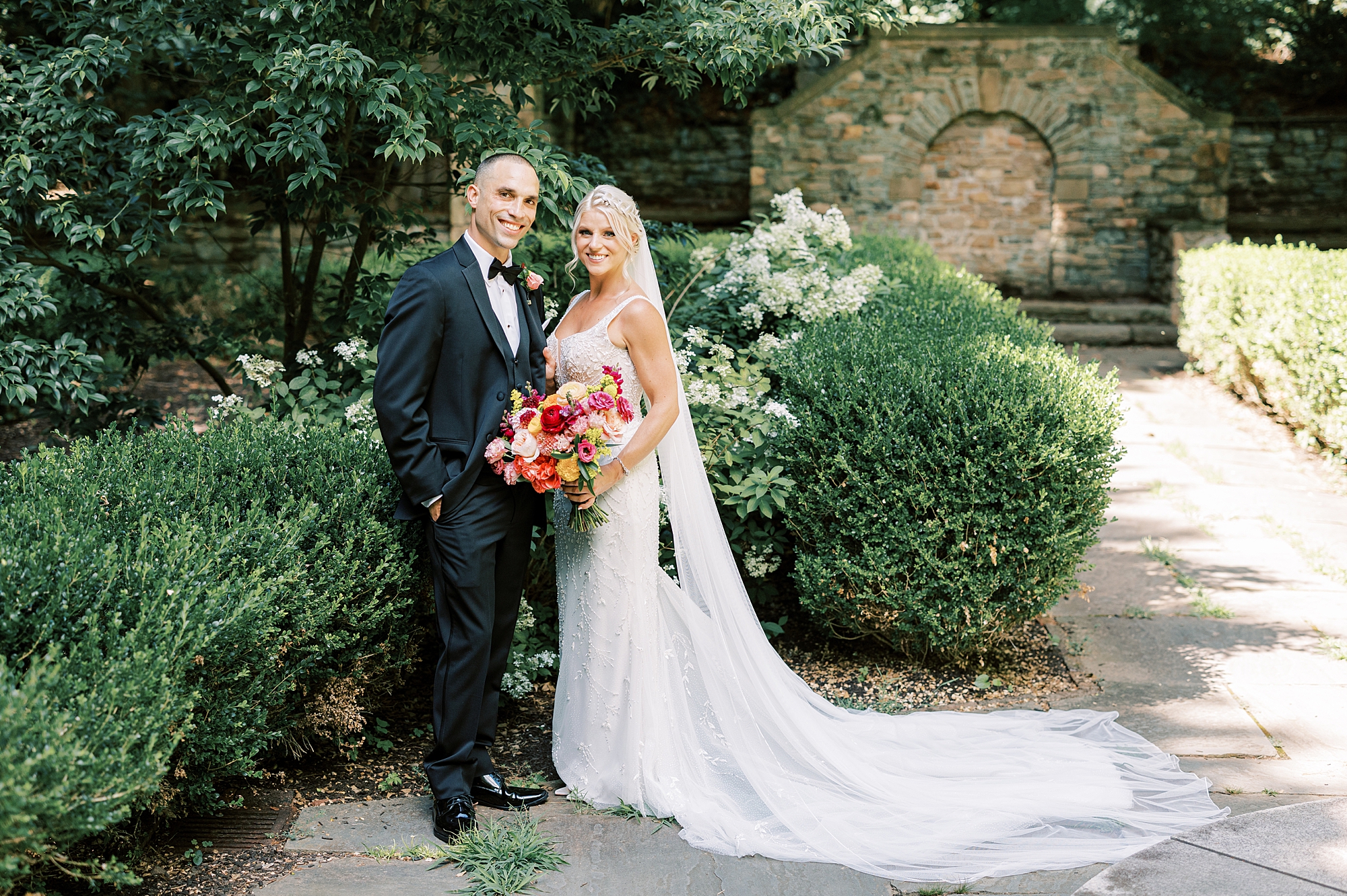 newlyweds pose by gardens at Parque Ridley Creek