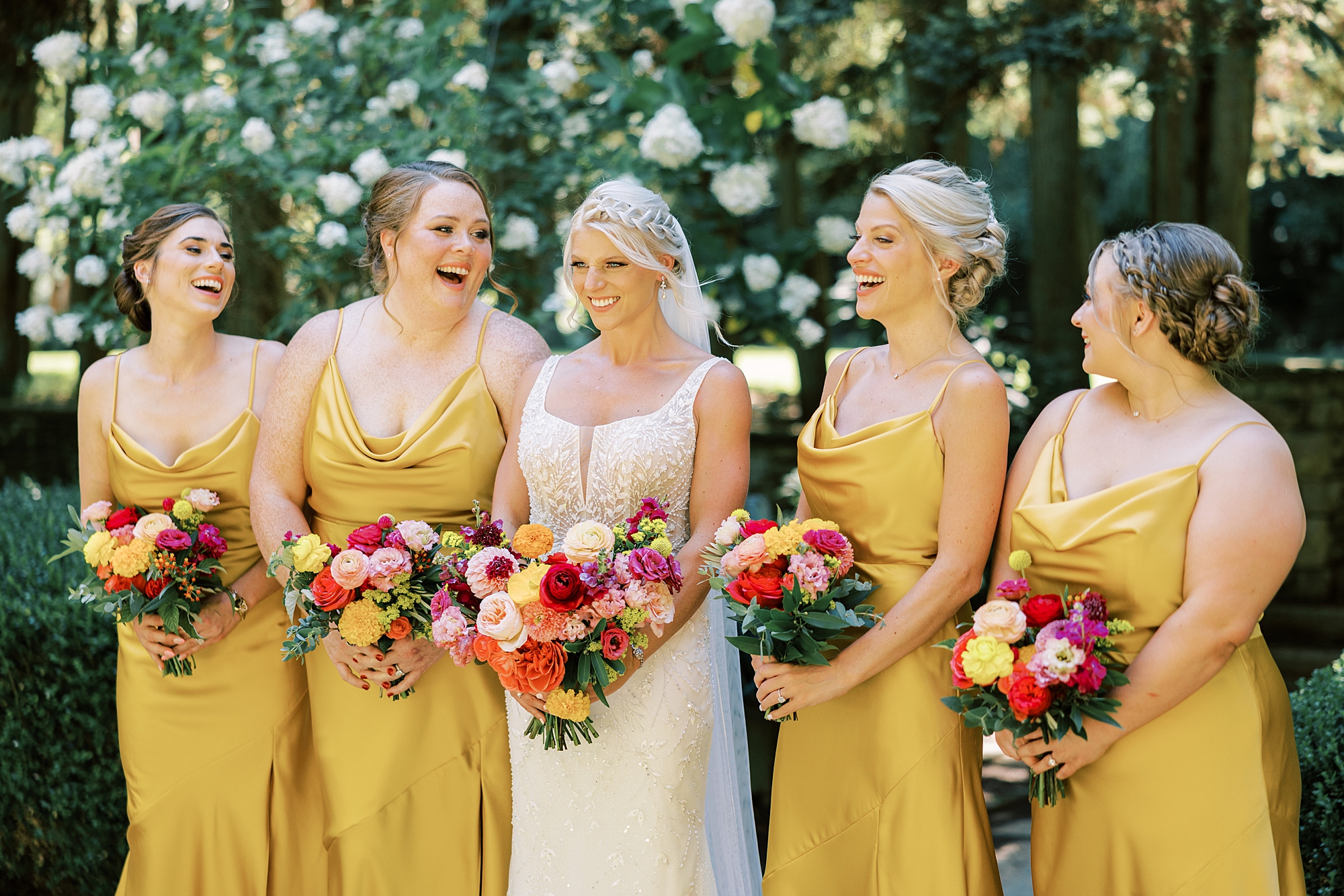 bride laughs with bridesmaids in gold gowns 