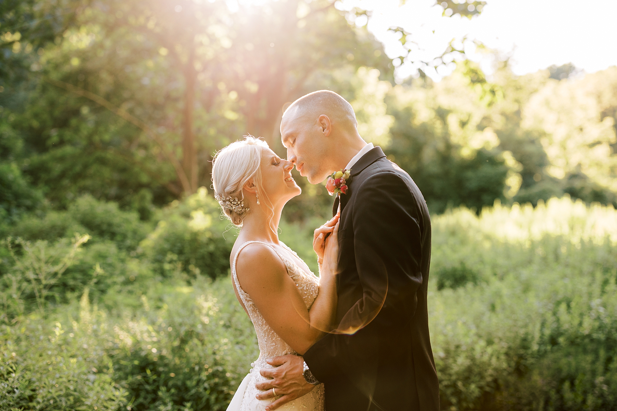 bride and groom lean in for kiss at sunset 