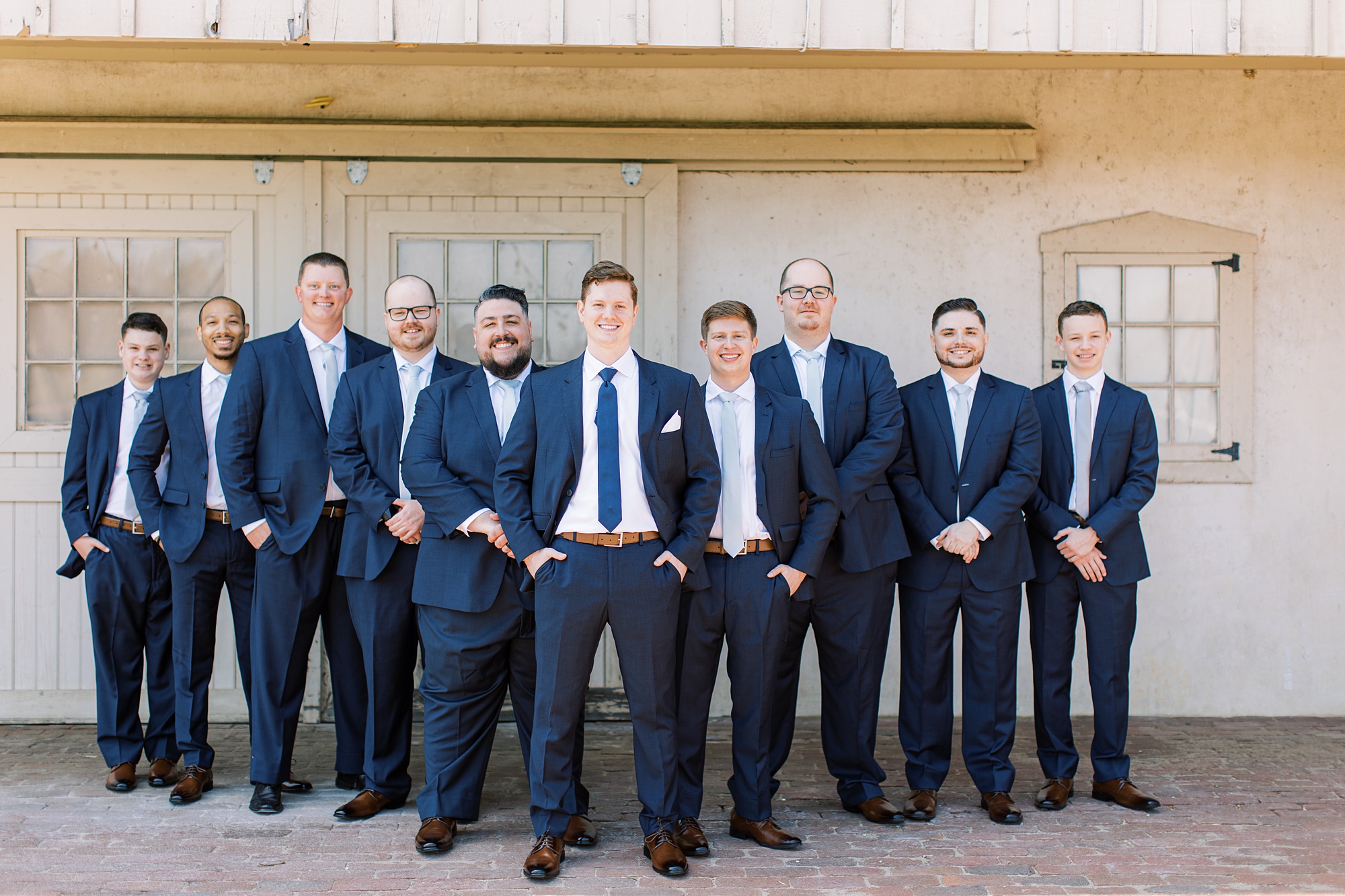 groom and groomsmen in navy suits stand outside French Creek Golf Club