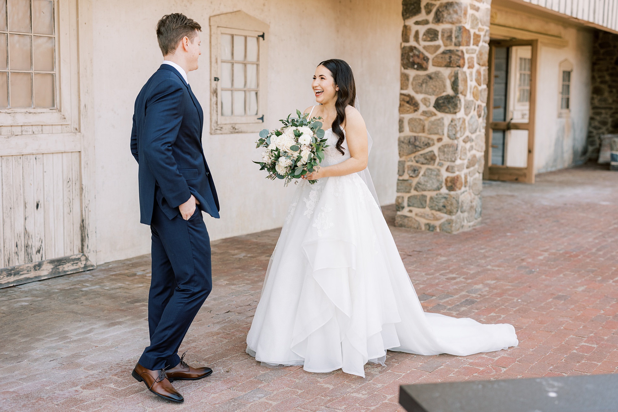 bride smiles and laughs during first look with groom at French Creek Golf Club