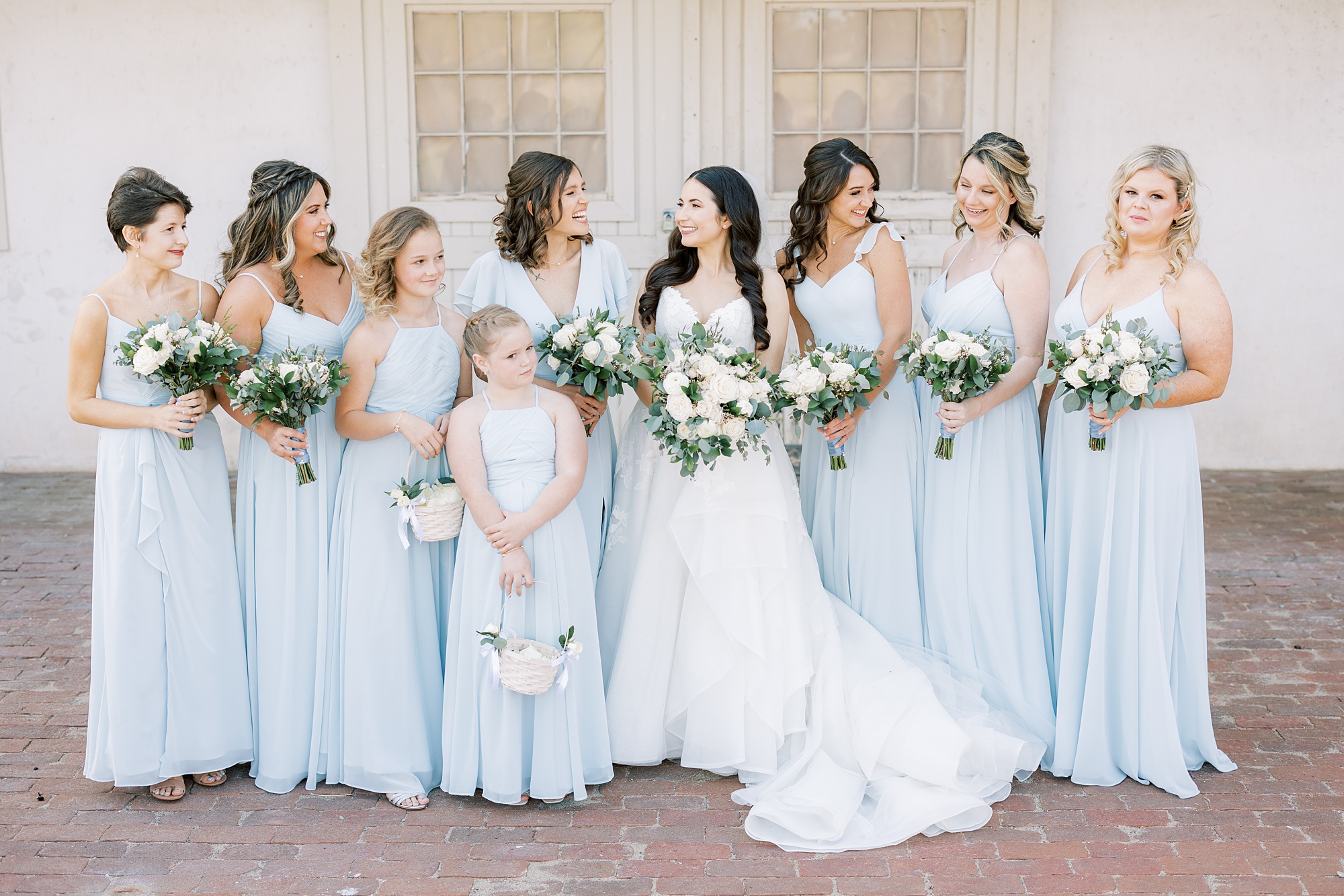 bride smiles at bridesmaids in pastel blue gowns at French Creek Golf Club